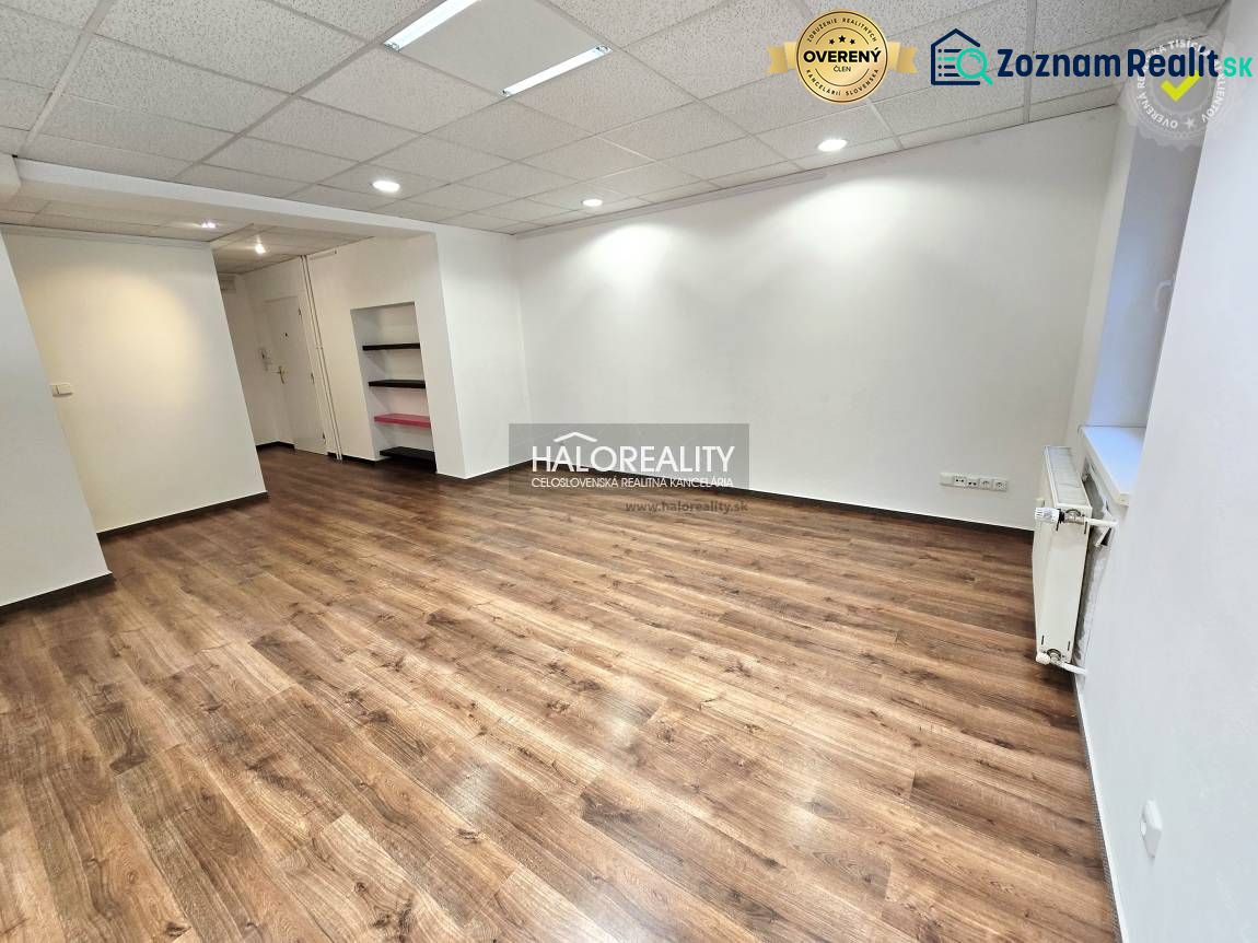 A room in a 3-bedroom apartment with a wooden-patterned floor and white walls.