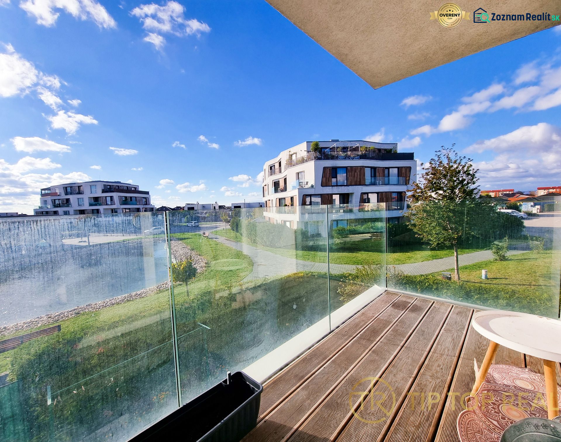 View from a 2-room apartment in Malinovo onto a grassy area with modern buildings.