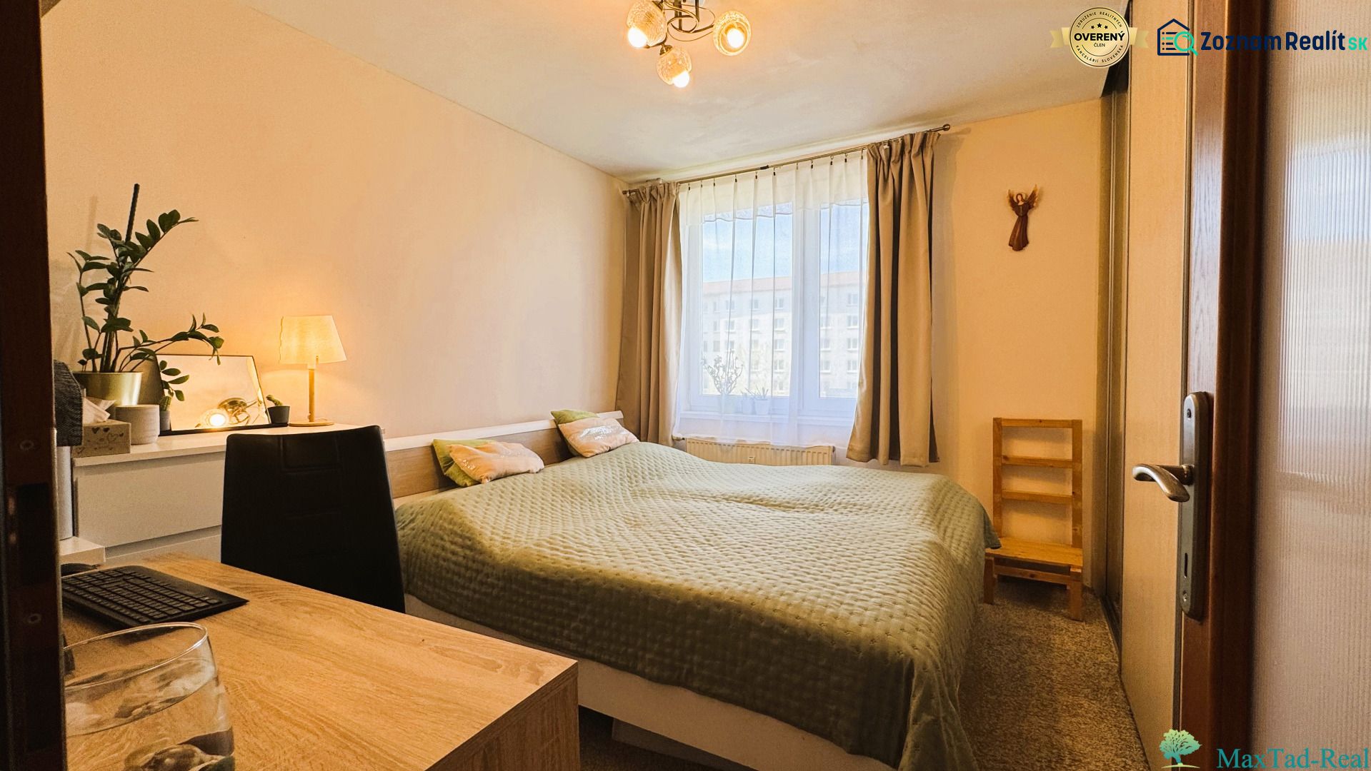 A bedroom in a 3-room apartment with a double bed and a window with curtains.