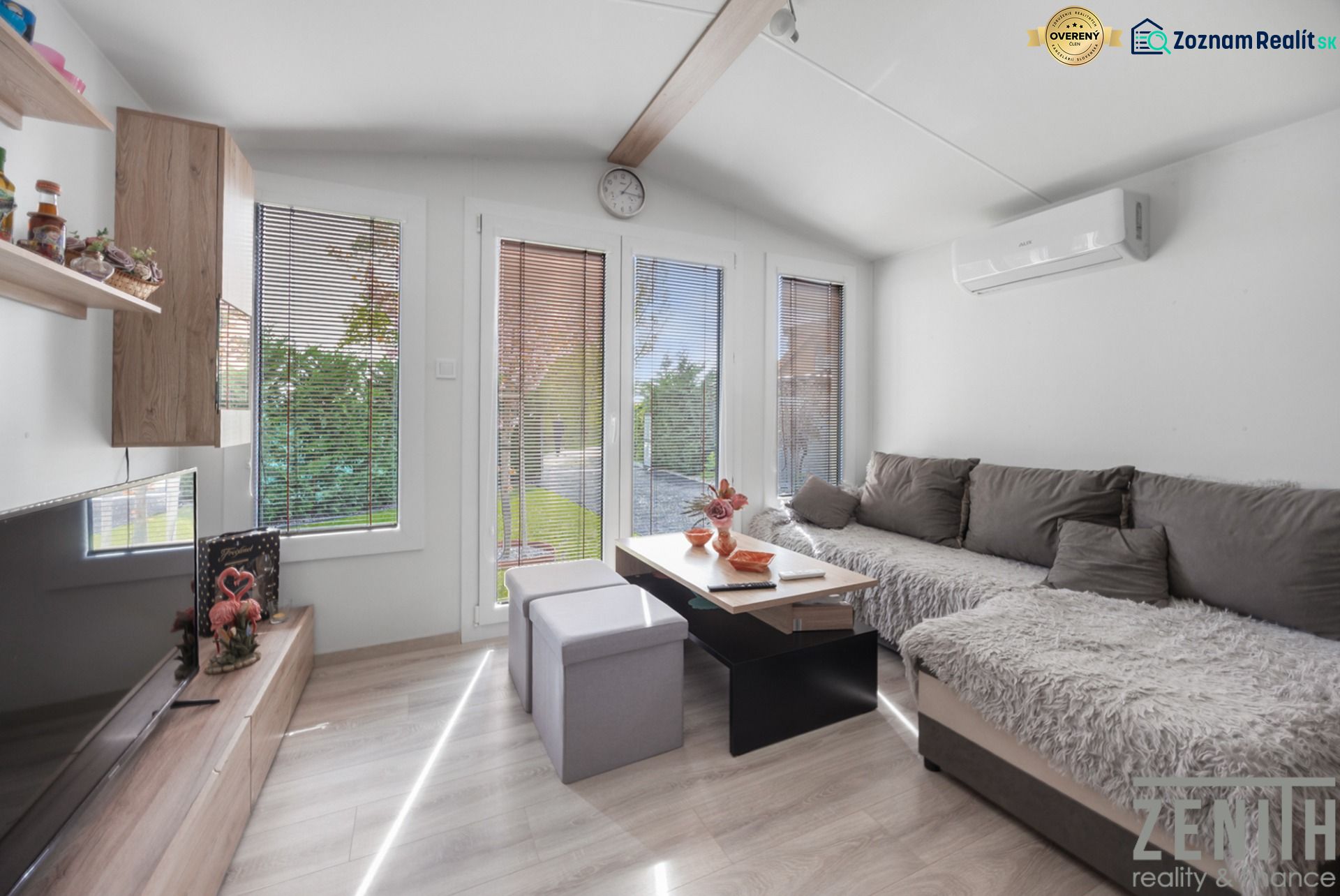 Living room in a cottage with wood-patterned flooring, a comfortable sofa, and decorative elements.