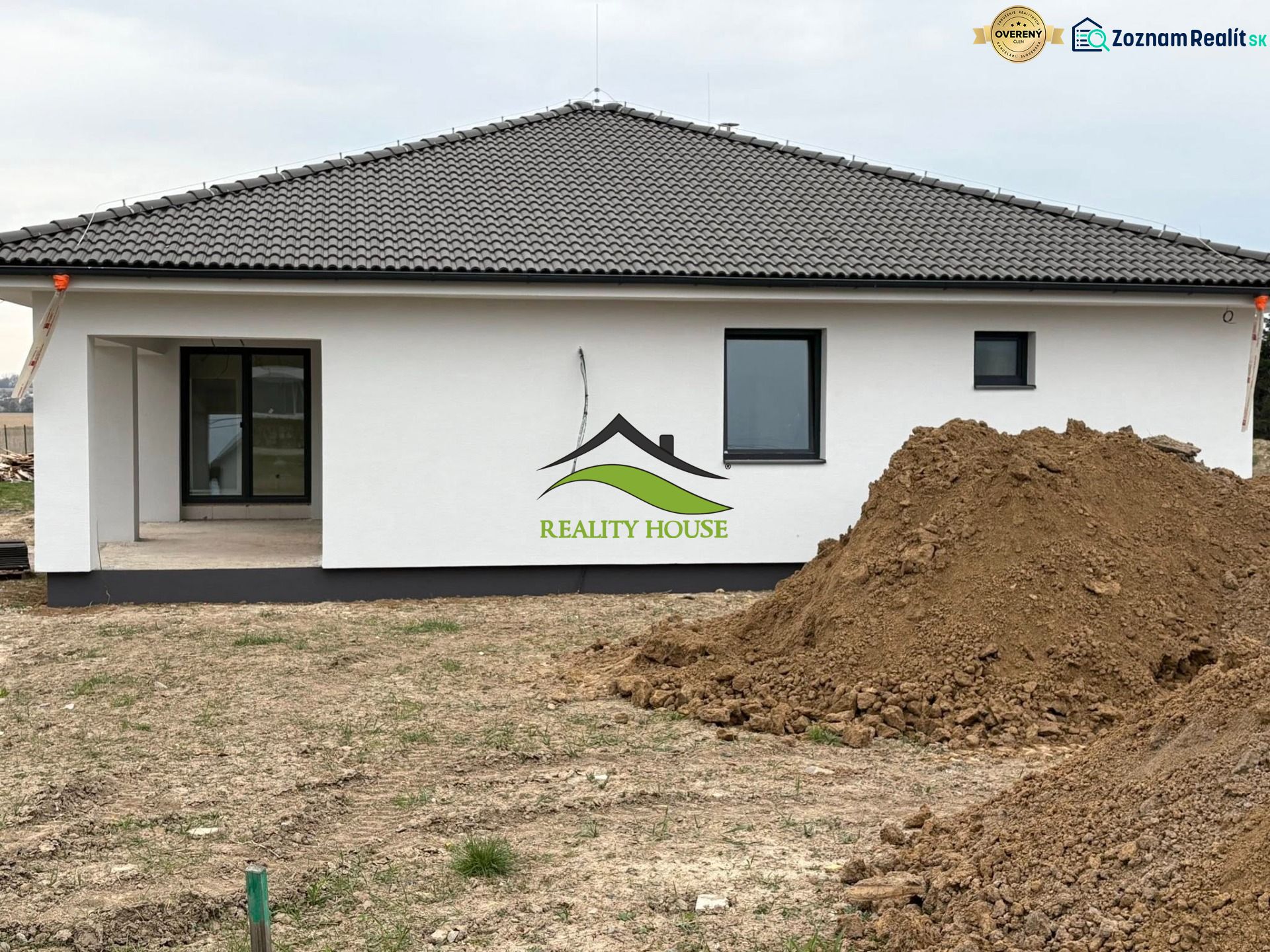 A family house on Hlavná Street in Michalovce, next to a pile of soil and a terrace.