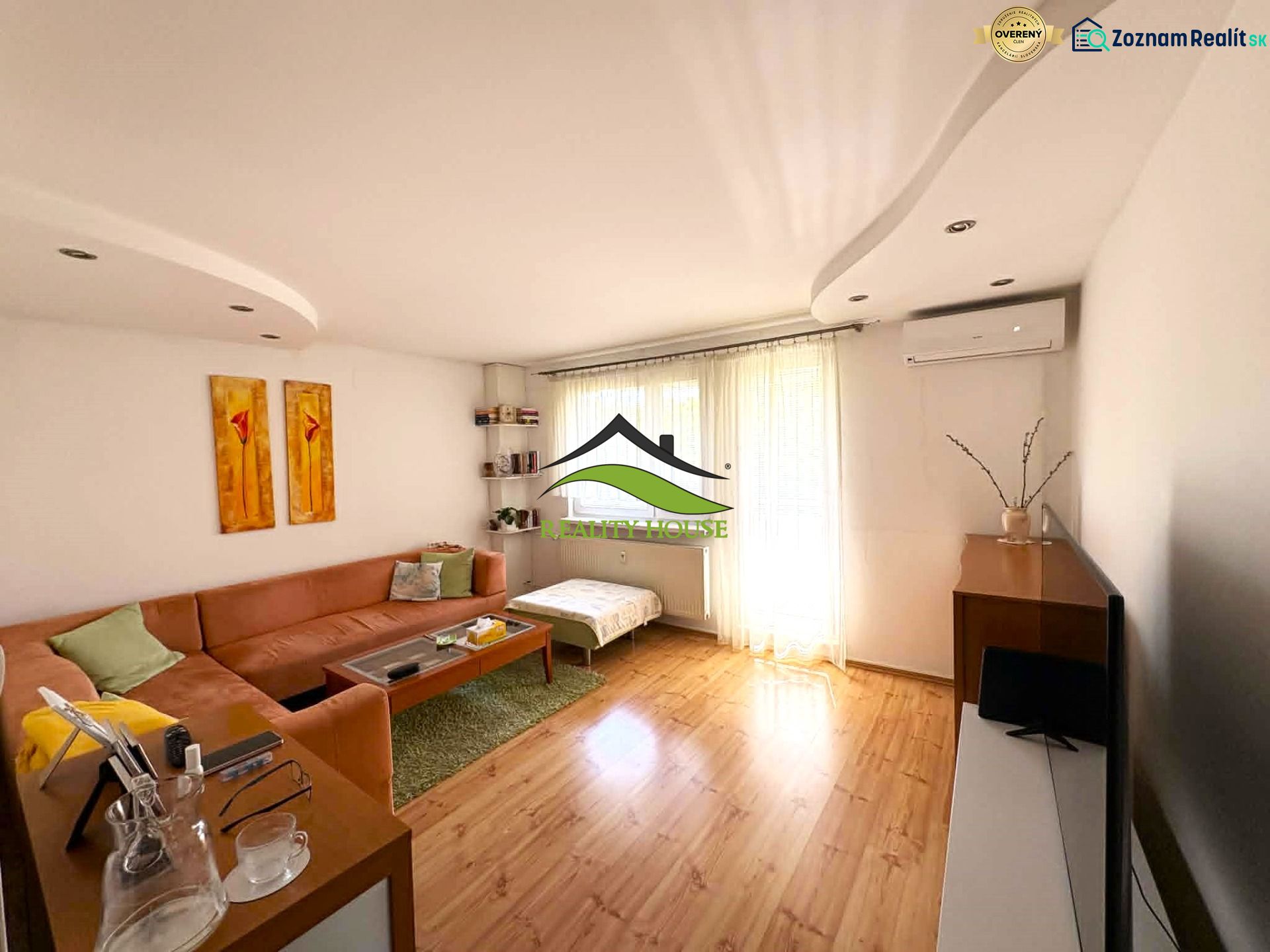 Living room with a sofa, wood-patterned flooring, and light-colored furniture in a 4-room apartment.