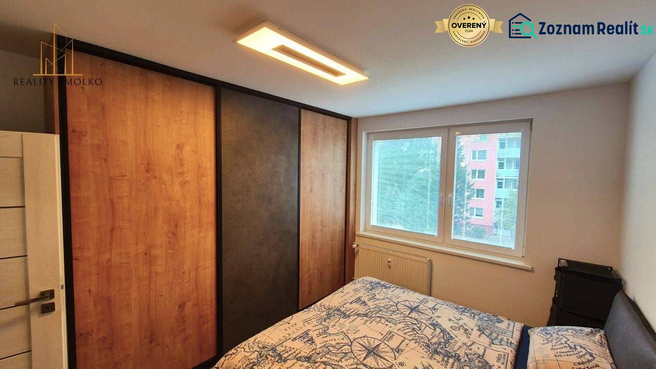 Bedroom in a 3-room apartment with a large wardrobe, bed, and window. Floor with wood decor.