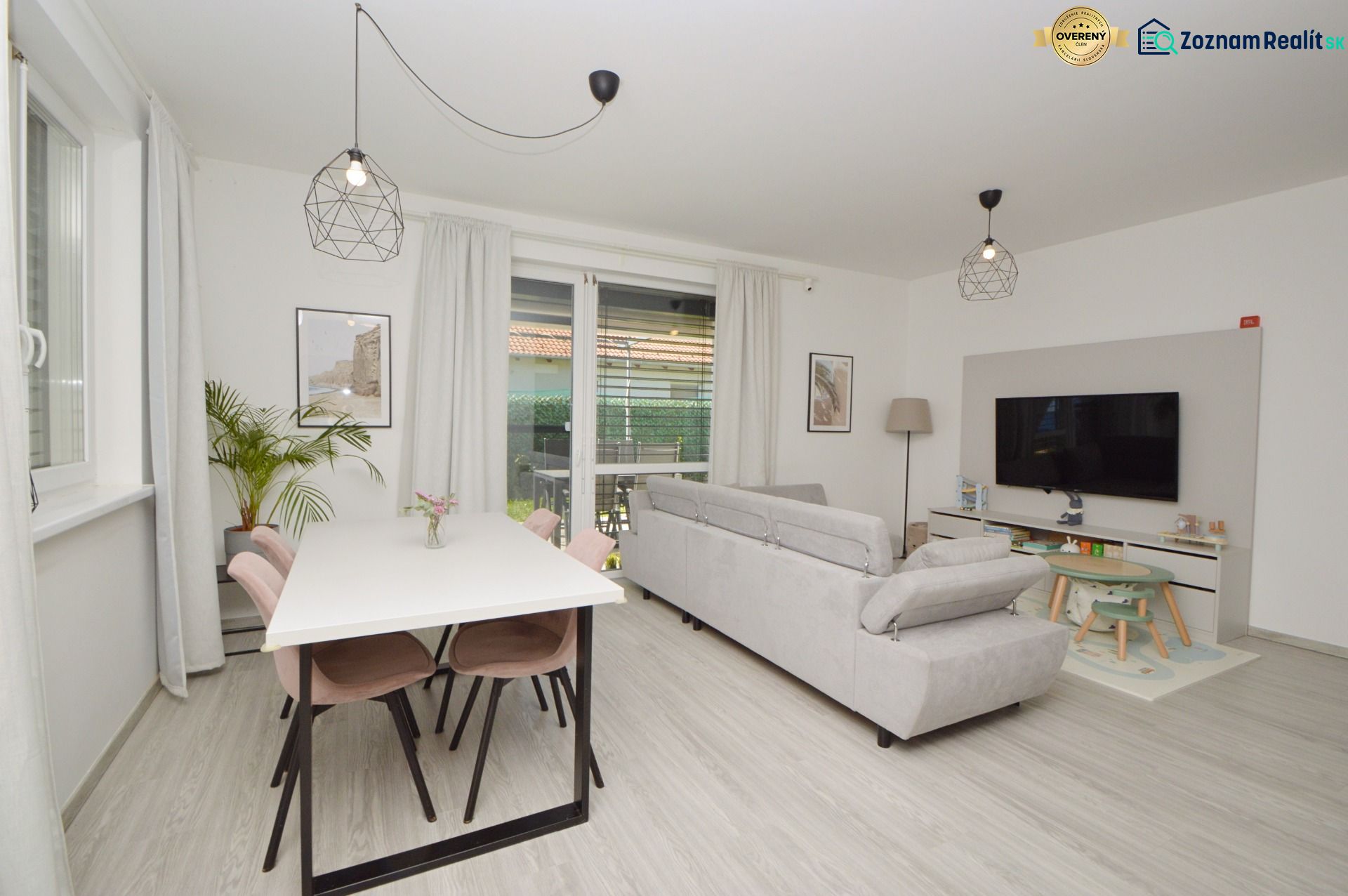 A family house with a wooden decor floor, a sofa, a table, and a television.