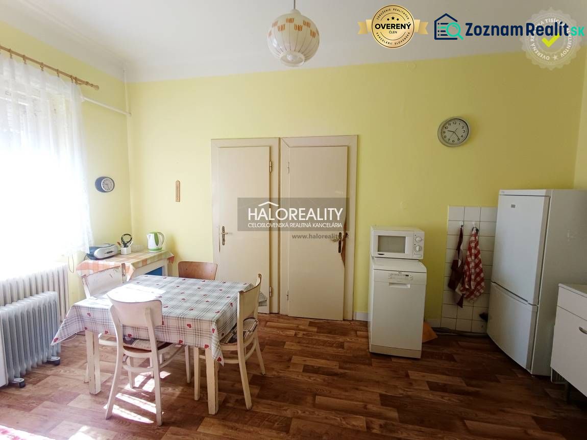 A kitchen in a 2-room apartment with a wooden decor floor and a dining table.