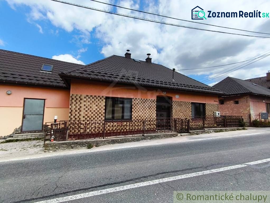 A family house in Reľov with brick cladding and a sloped metal roof.