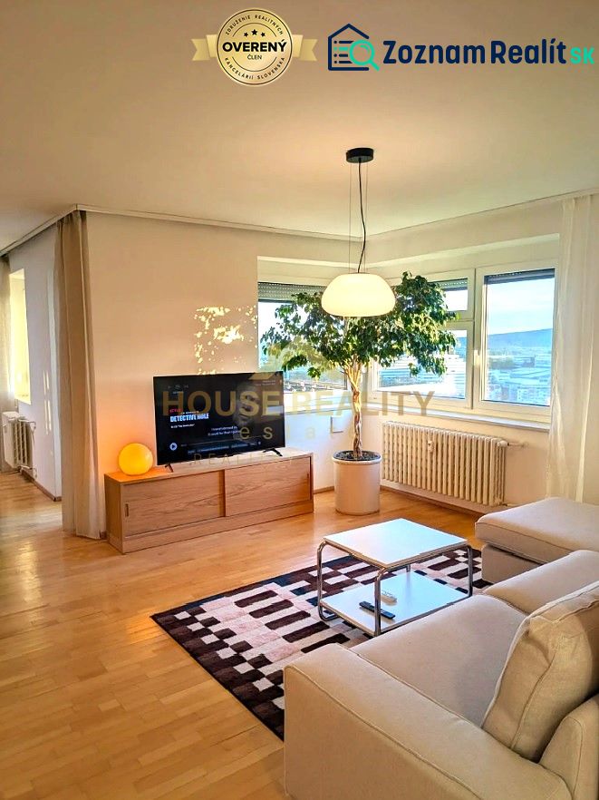 Living room in a 4-room apartment with a wood-decor floor, sofa, and television.