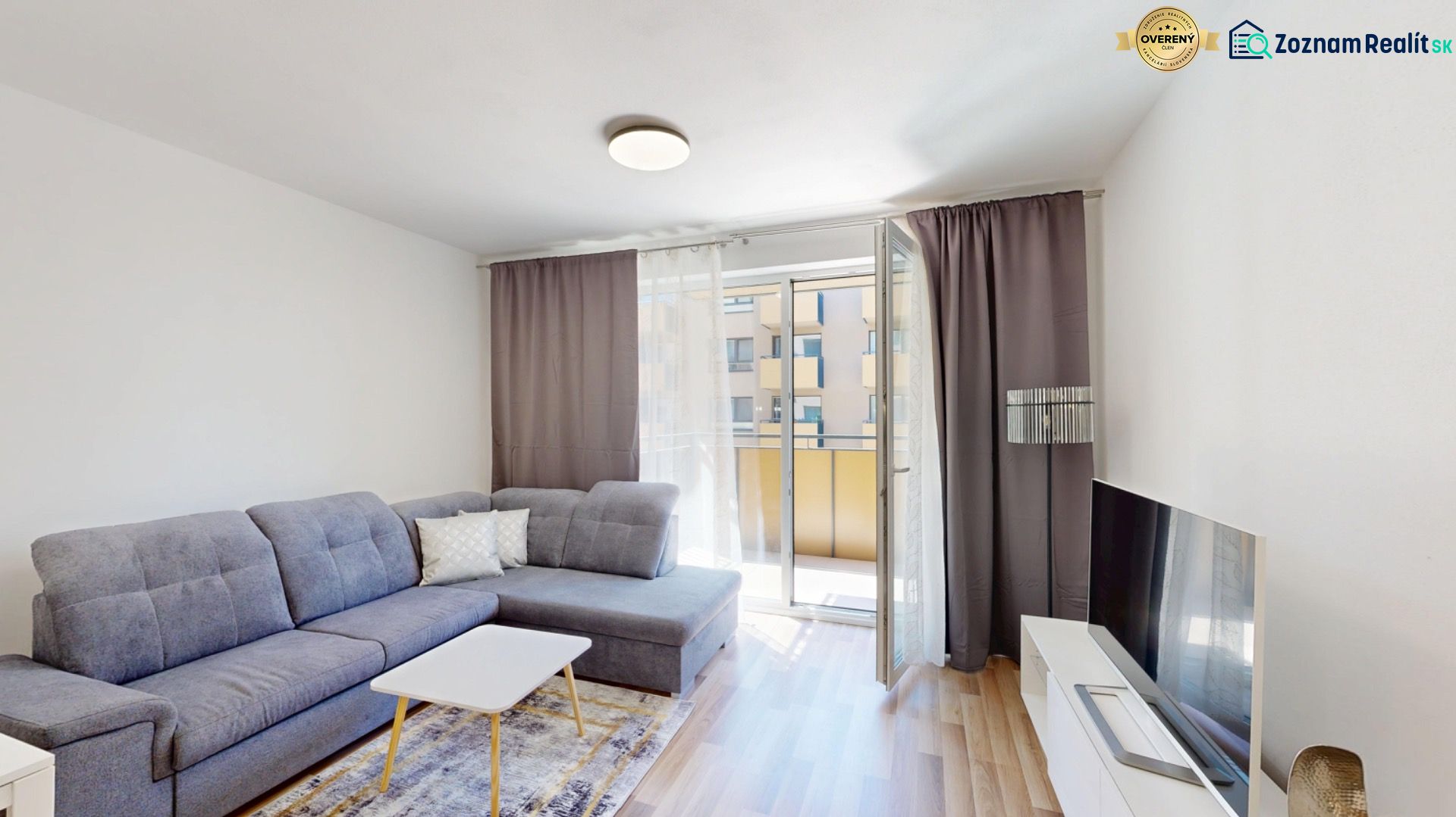 Living room in a two-room apartment with a corner sofa and a floor with a wooden decor.