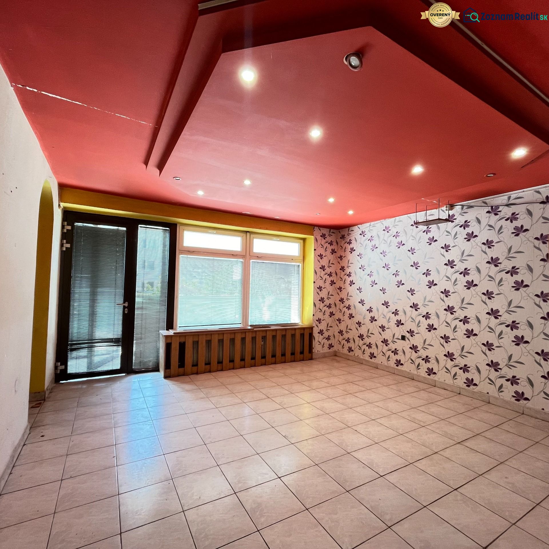 Commercial space with a red ceiling, tiled floor, and floral wallpaper.