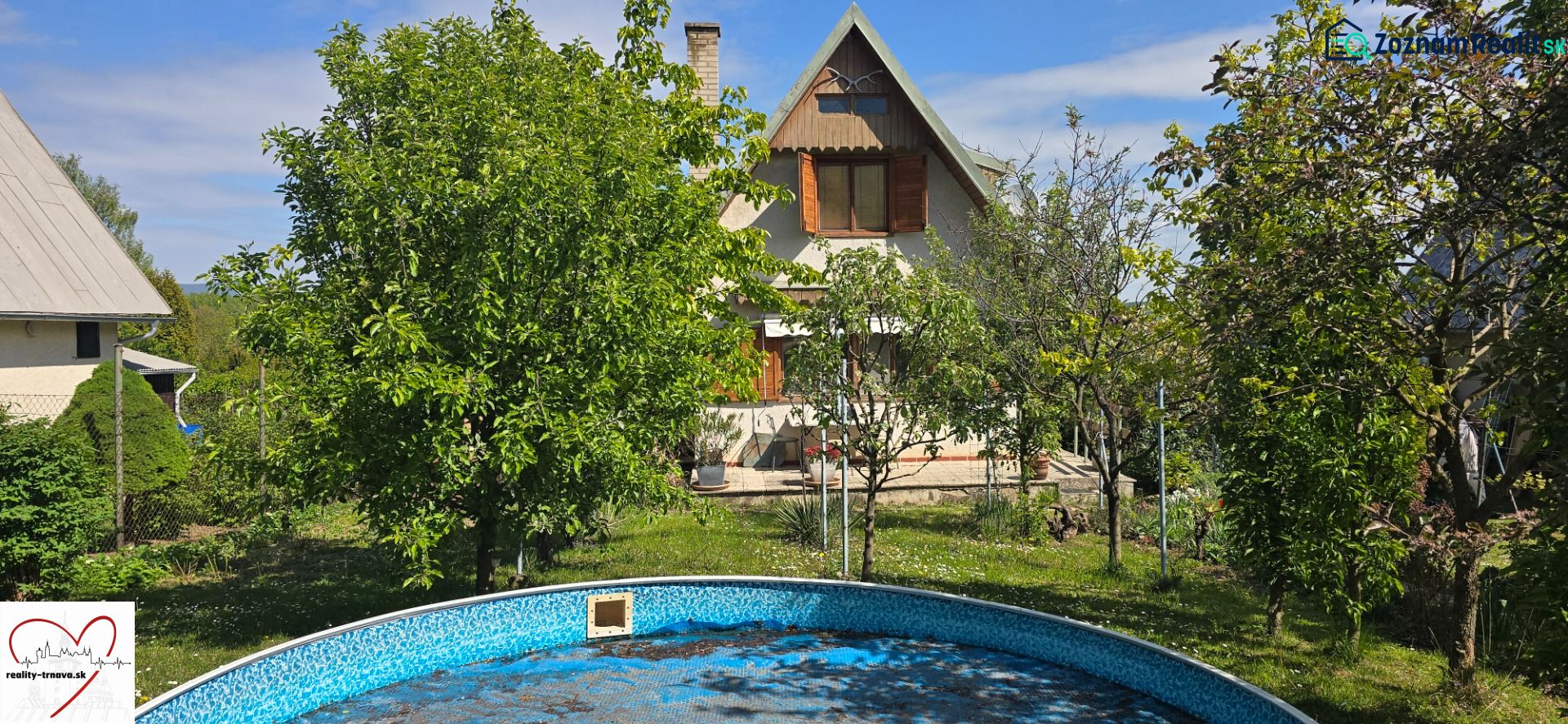 A cottage in Suchá nad Parnou, Nové Vinohrady, surrounded by greenery and a swimming pool.