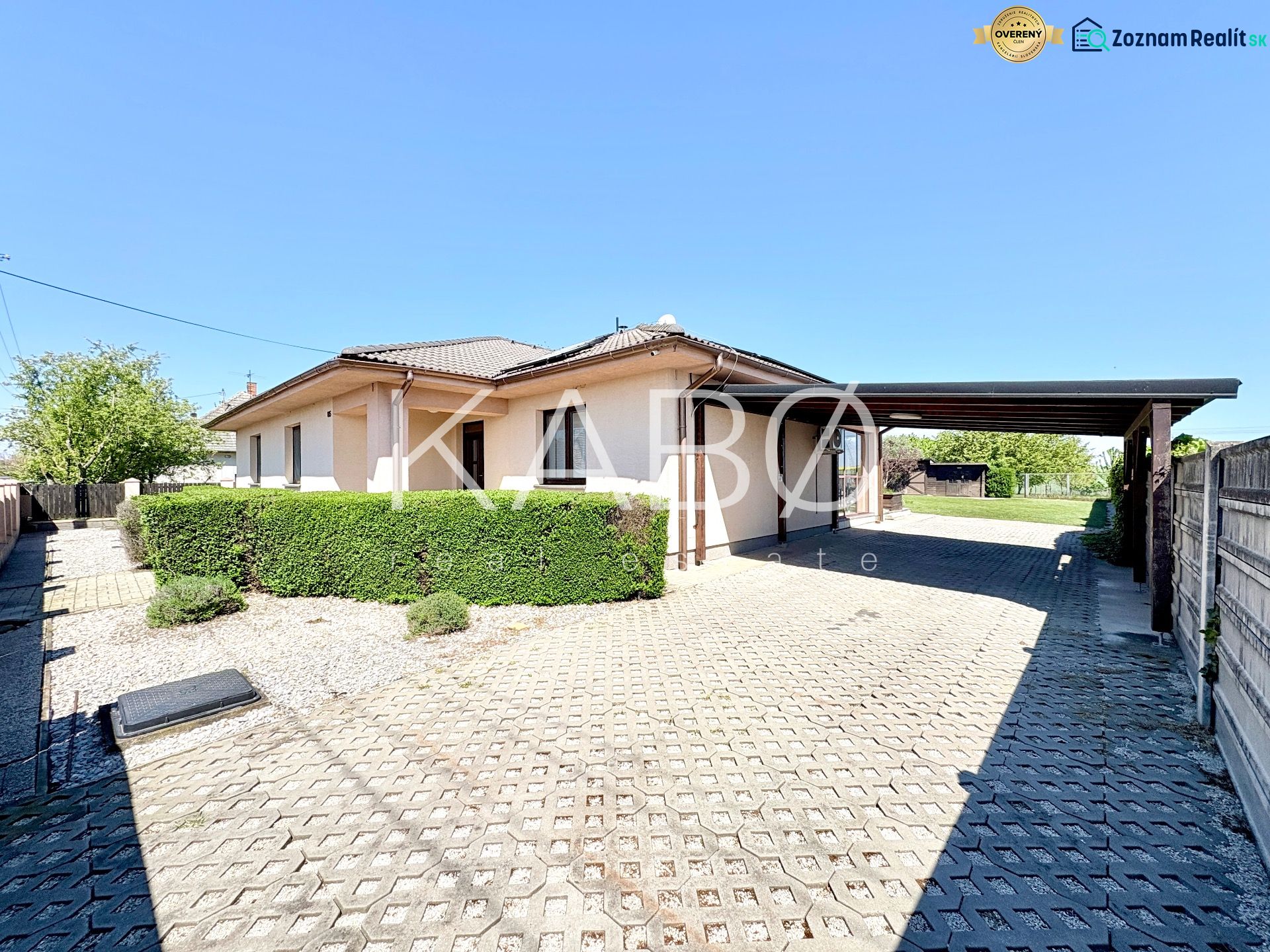 A family house on Močenská Street in Cabaj-Čápor with a covered parking space and a live hedge.