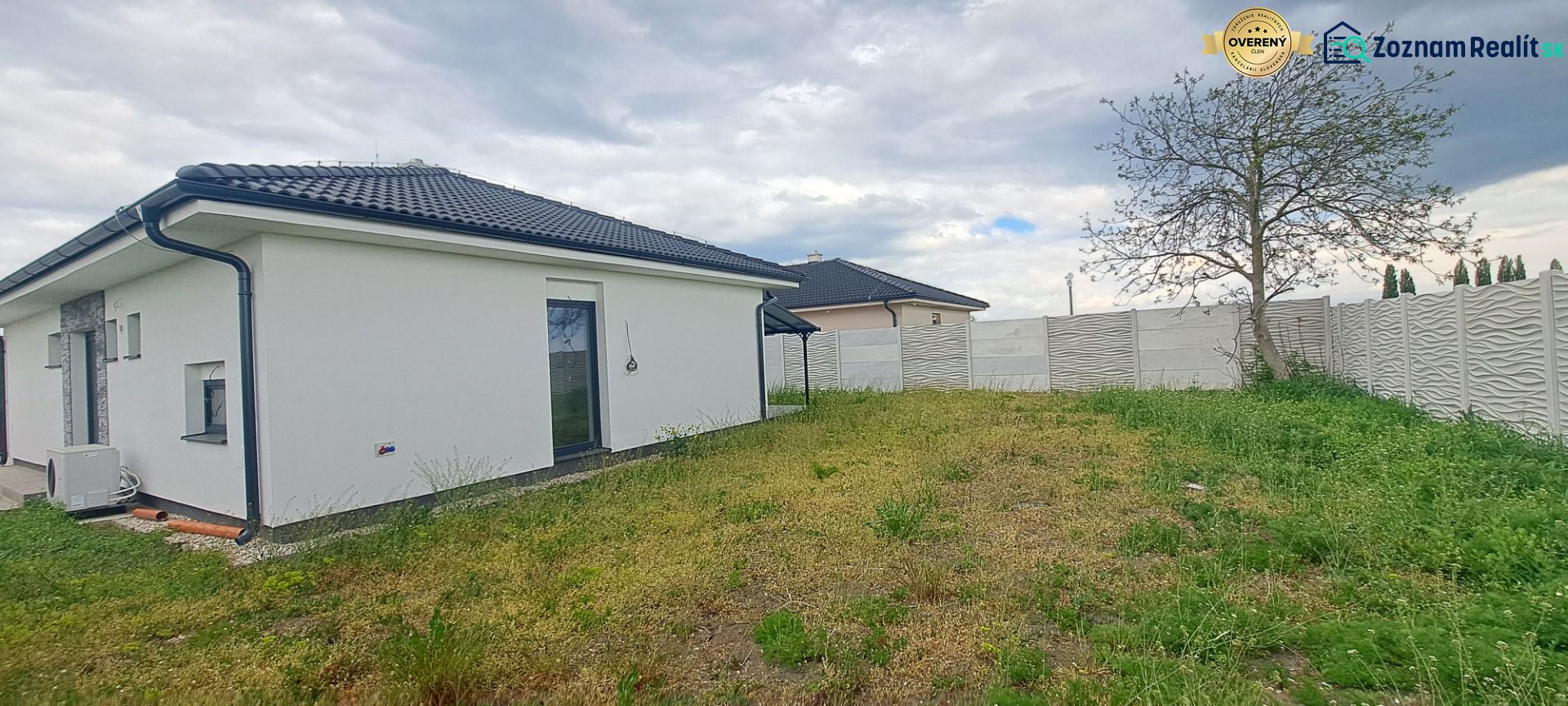 A family house in Topoľnica with a white facade, garden, and fence.