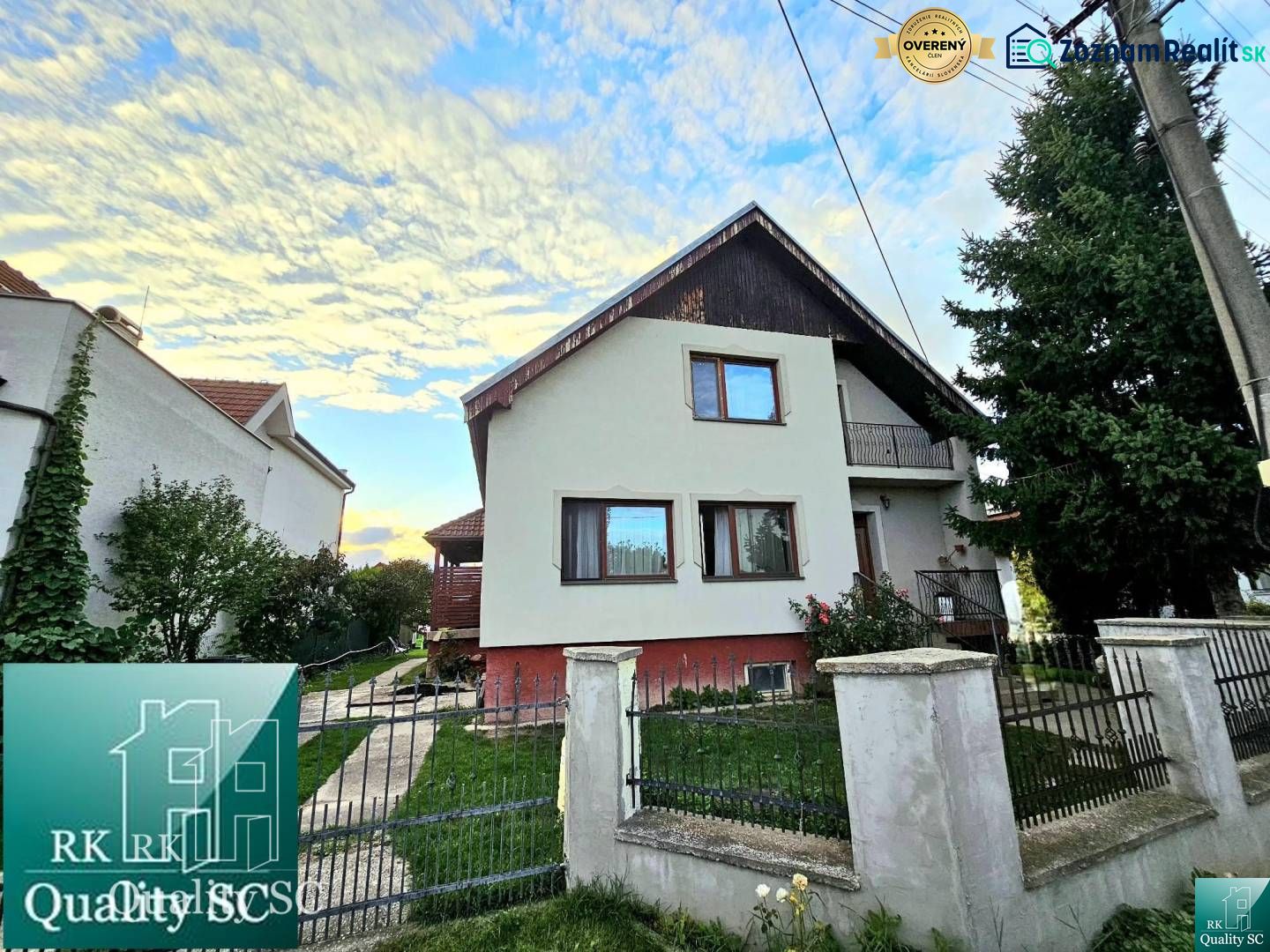 A family house in Tureň on Tureň Street with a fenced garden and a blue sky.