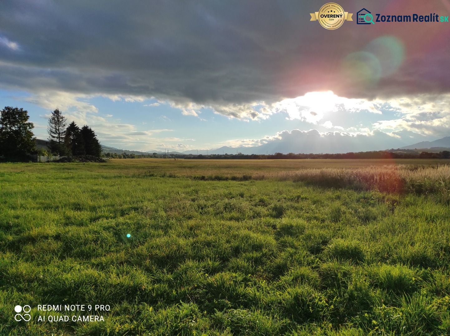 Extensive green lands, ideal for living, under the sun behind the clouds.