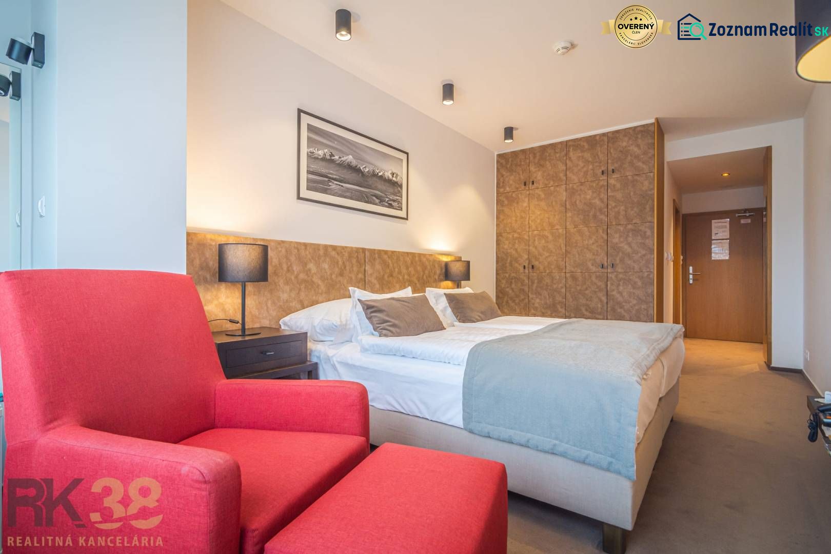 Recreational apartment with a double bed, red armchair, and built-in wardrobe.