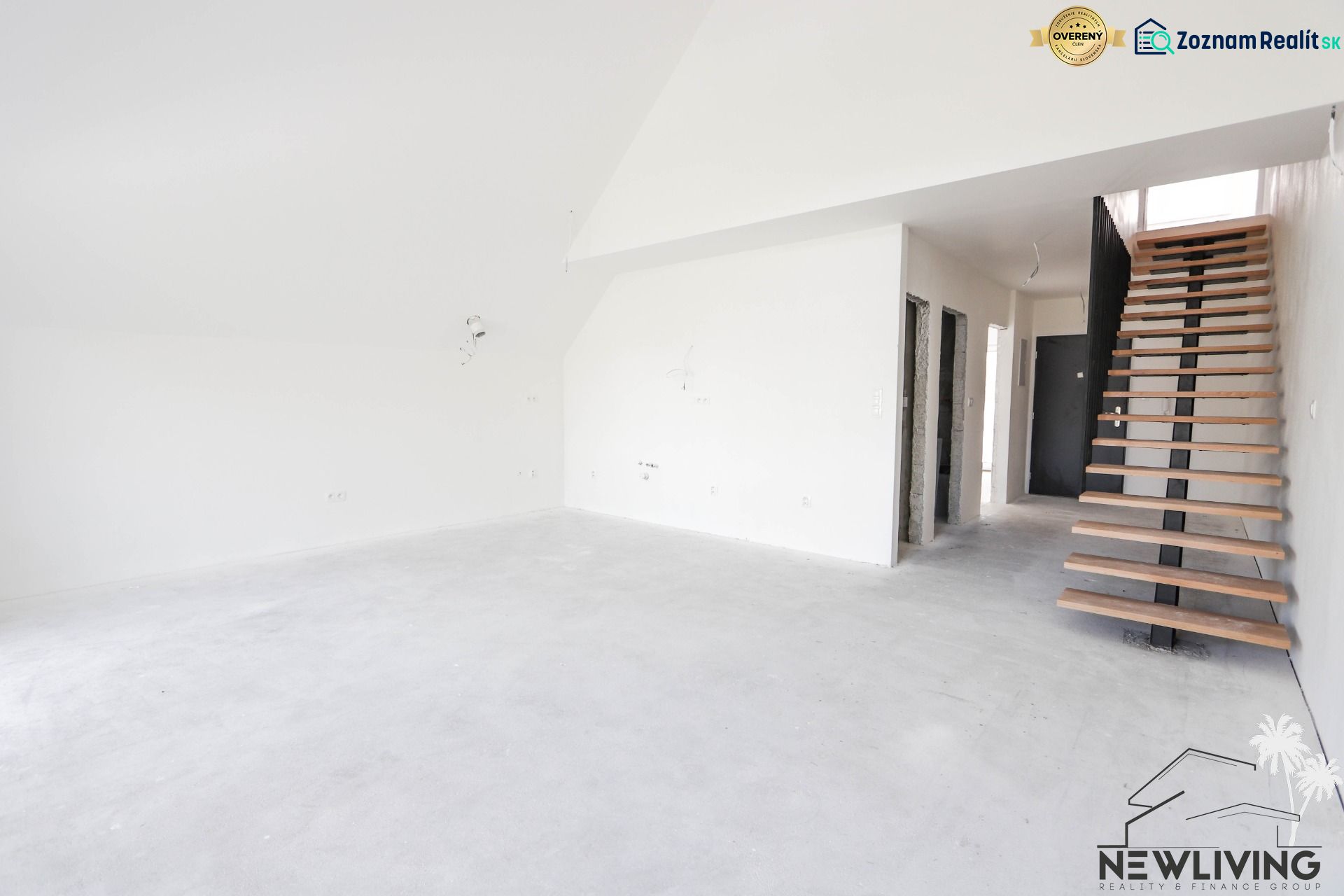Interior of a 4-room apartment with a concrete floor and wooden staircase.
