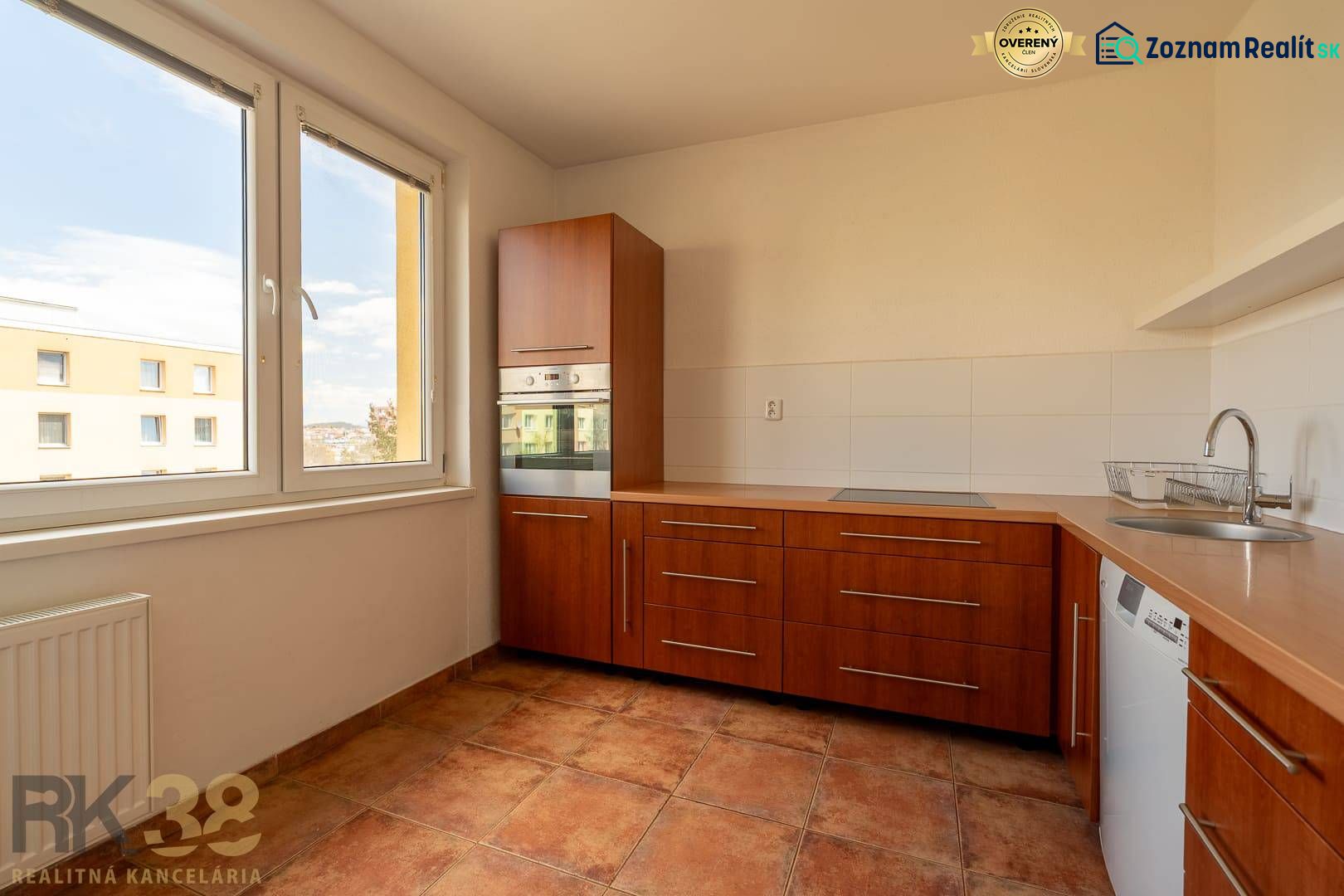 A kitchen unit in a 4-room apartment with a large window and built-in appliances.