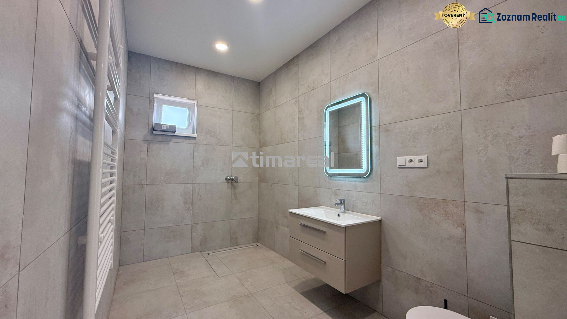 Bathroom in a family house with a modern sink, mirror, and ladder radiator.