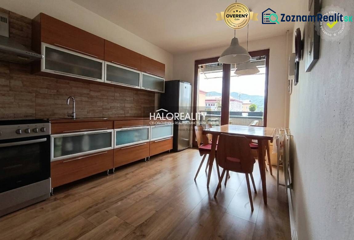 A kitchen in a 3-room apartment with a wooden decor floor and a dining table.