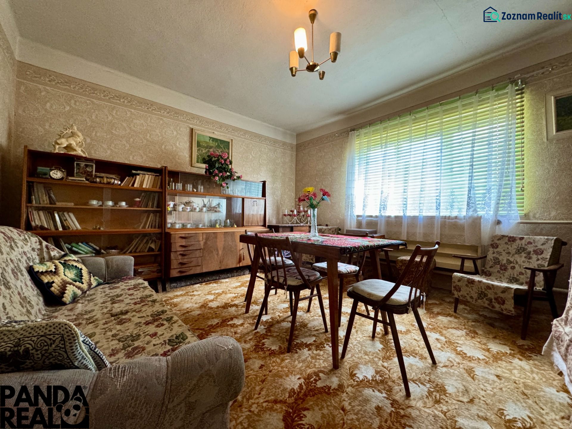 Living room in a family house with antique furniture, floral decor, and a carpet.