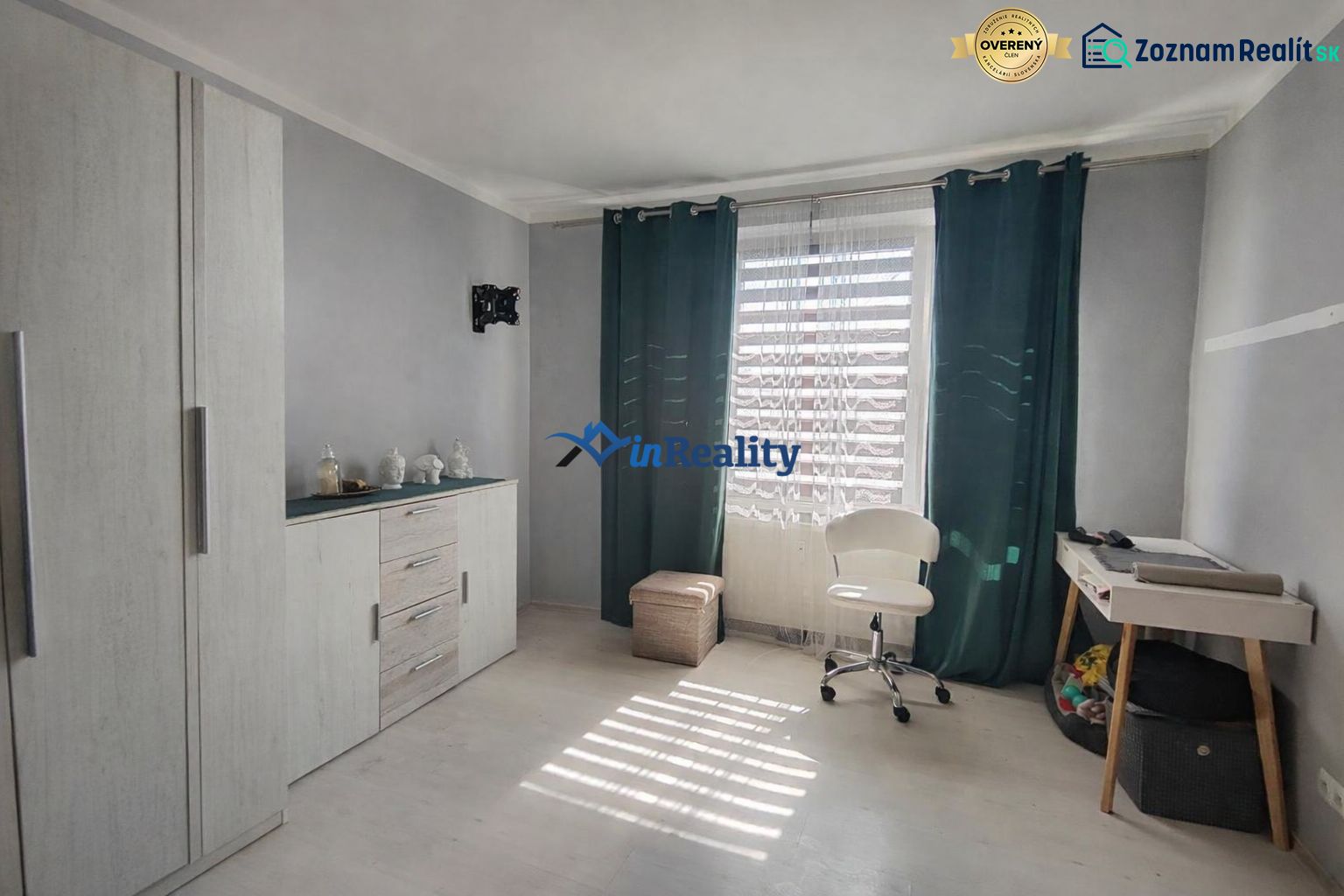 A room in a one-room apartment, light floor with wood decor, chair and table.