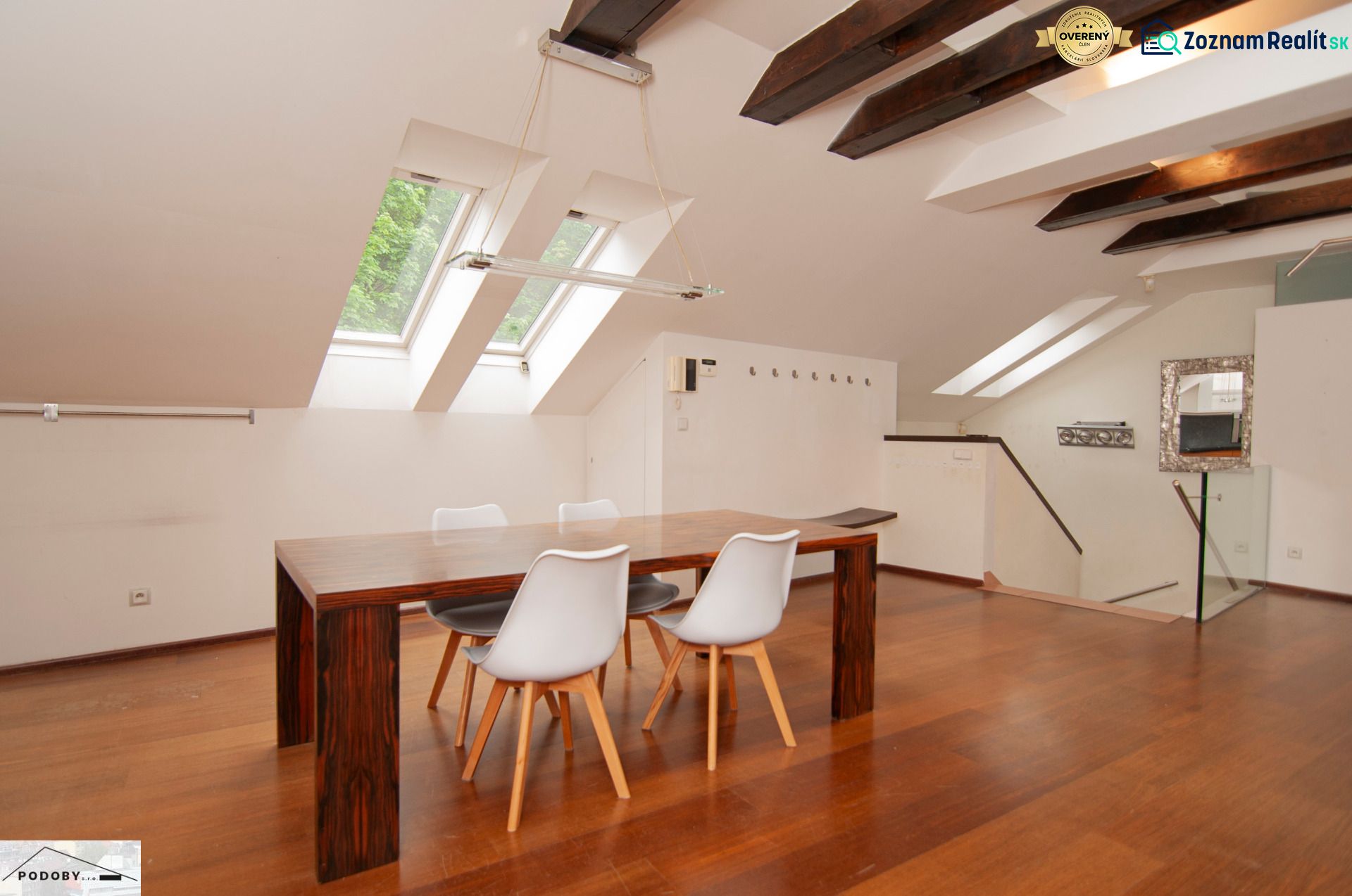 A bright dining room in a three-room apartment with wood-patterned flooring and skylights.