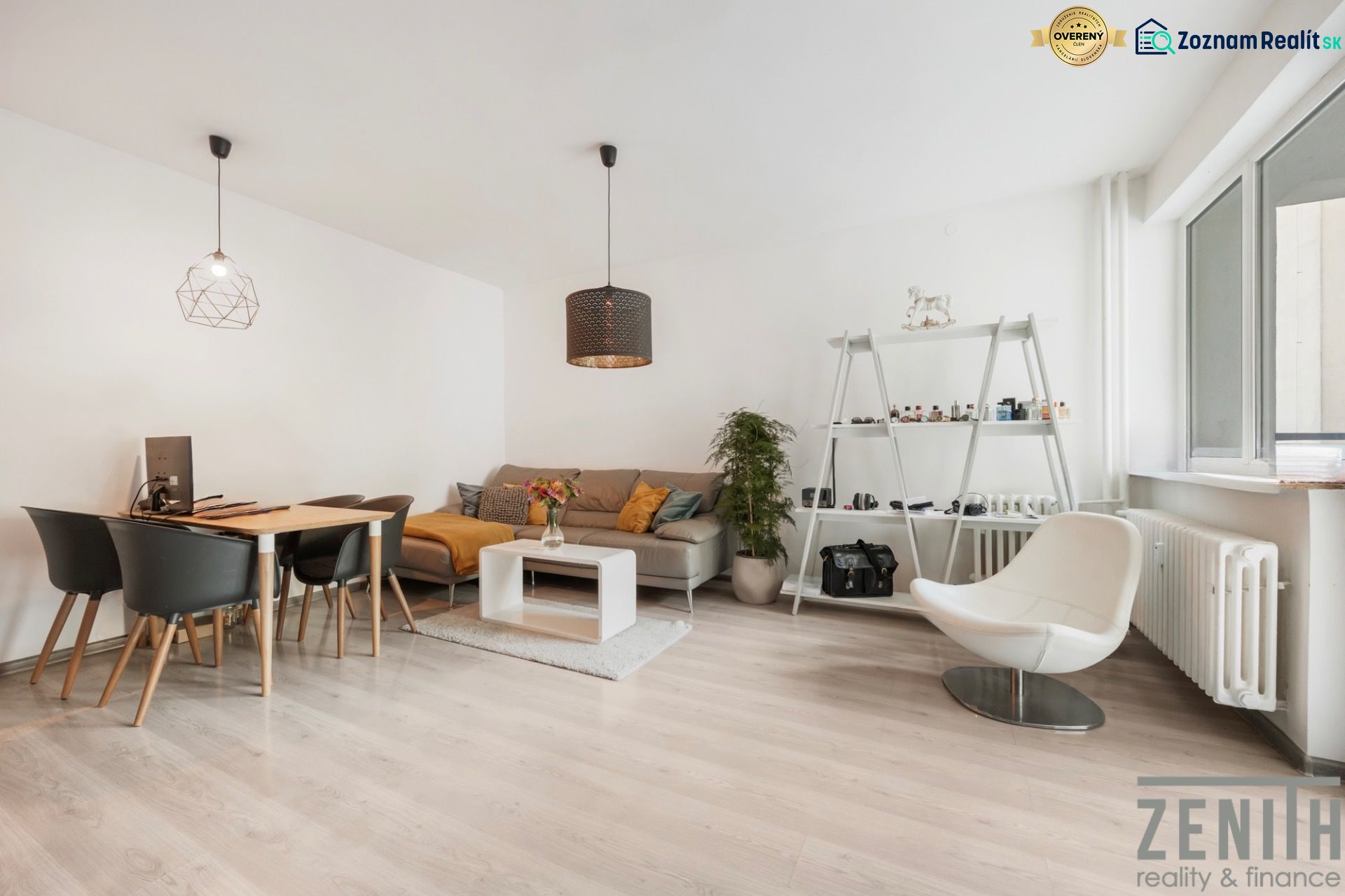 Living room in a two-room apartment with a light wood-patterned floor, modern furniture, and decorations.