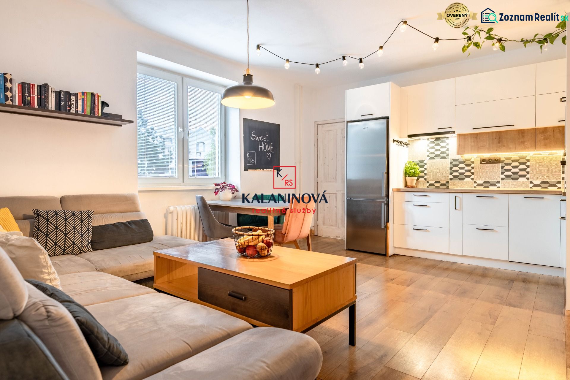 Living room with kitchen, wooden decor flooring, sofa and dining table.