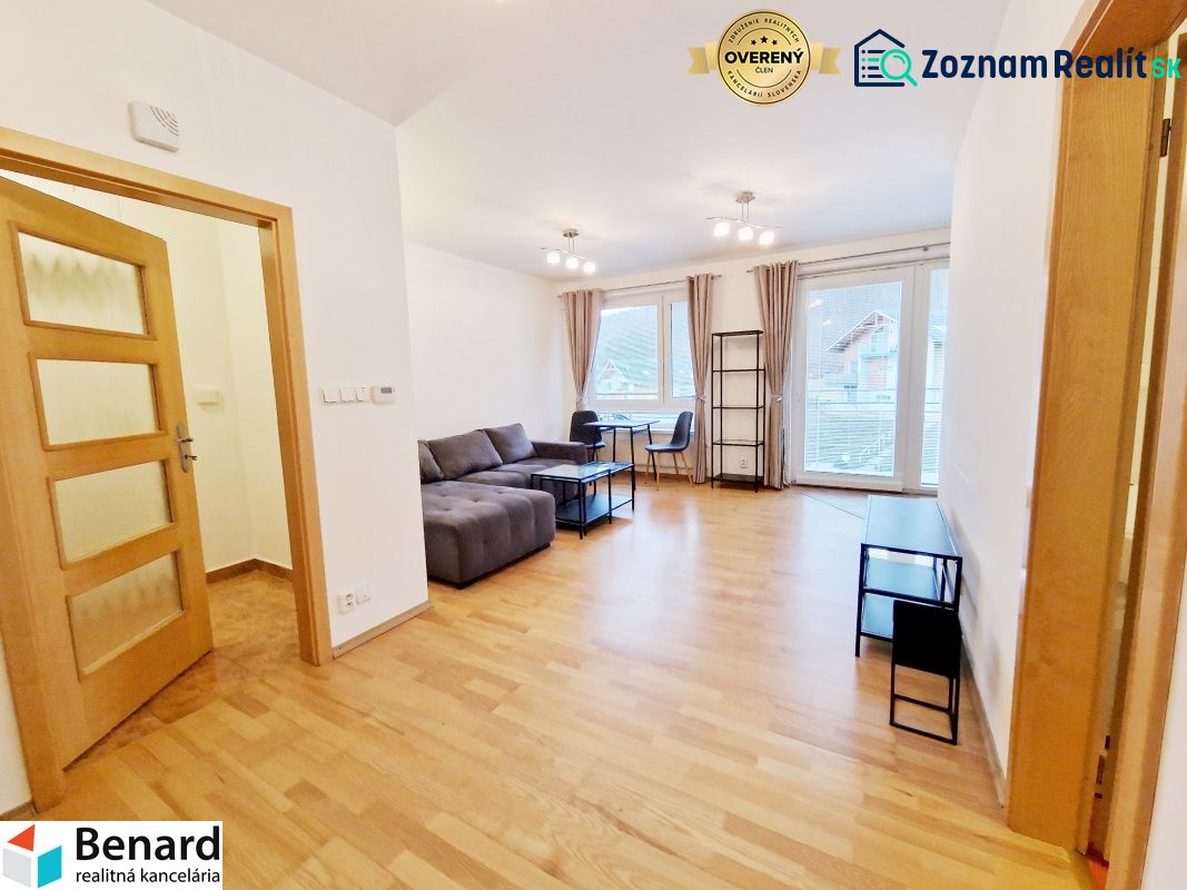 Living room in a three-room apartment with a wooden decor floor and a sofa.