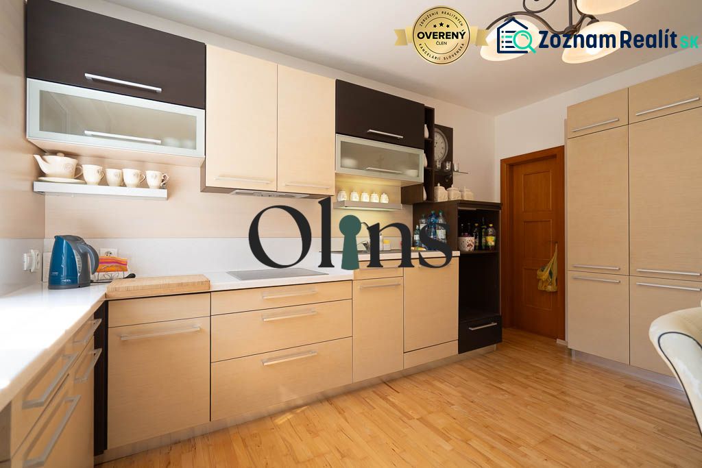 A kitchen in a family house with a wooden decor floor and light-colored furniture.