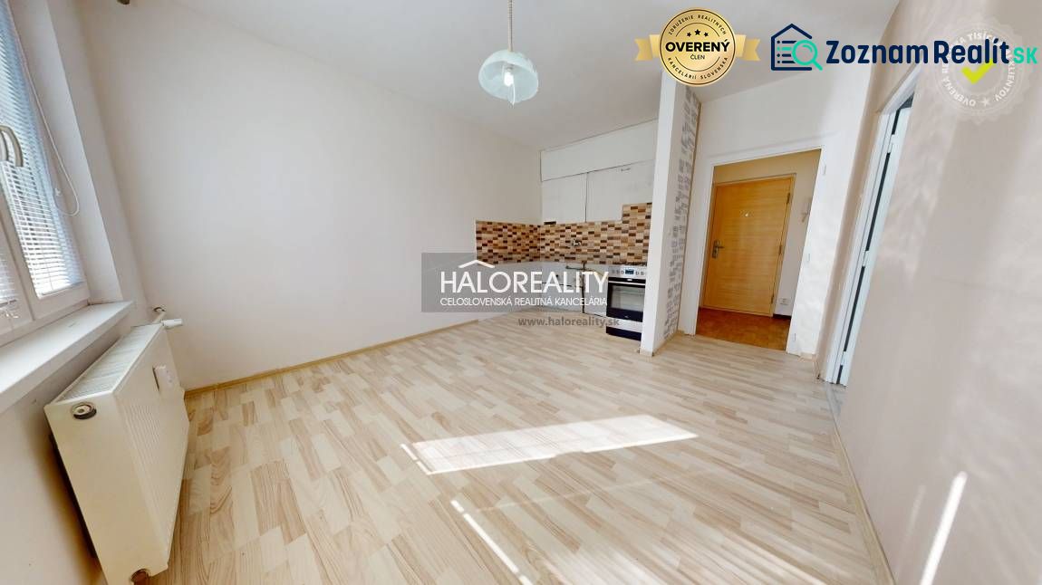 Kitchen in a studio apartment with a wooden decor floor and ceramic tiles.