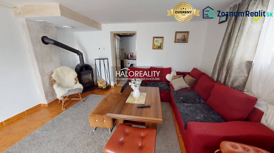 Living room in a family house with a fireplace, a comfortable sofa, and a wooden table.