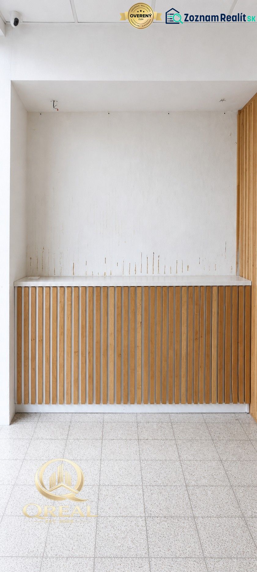 Commercial spaces with white walls and wooden decor, tiled floor.