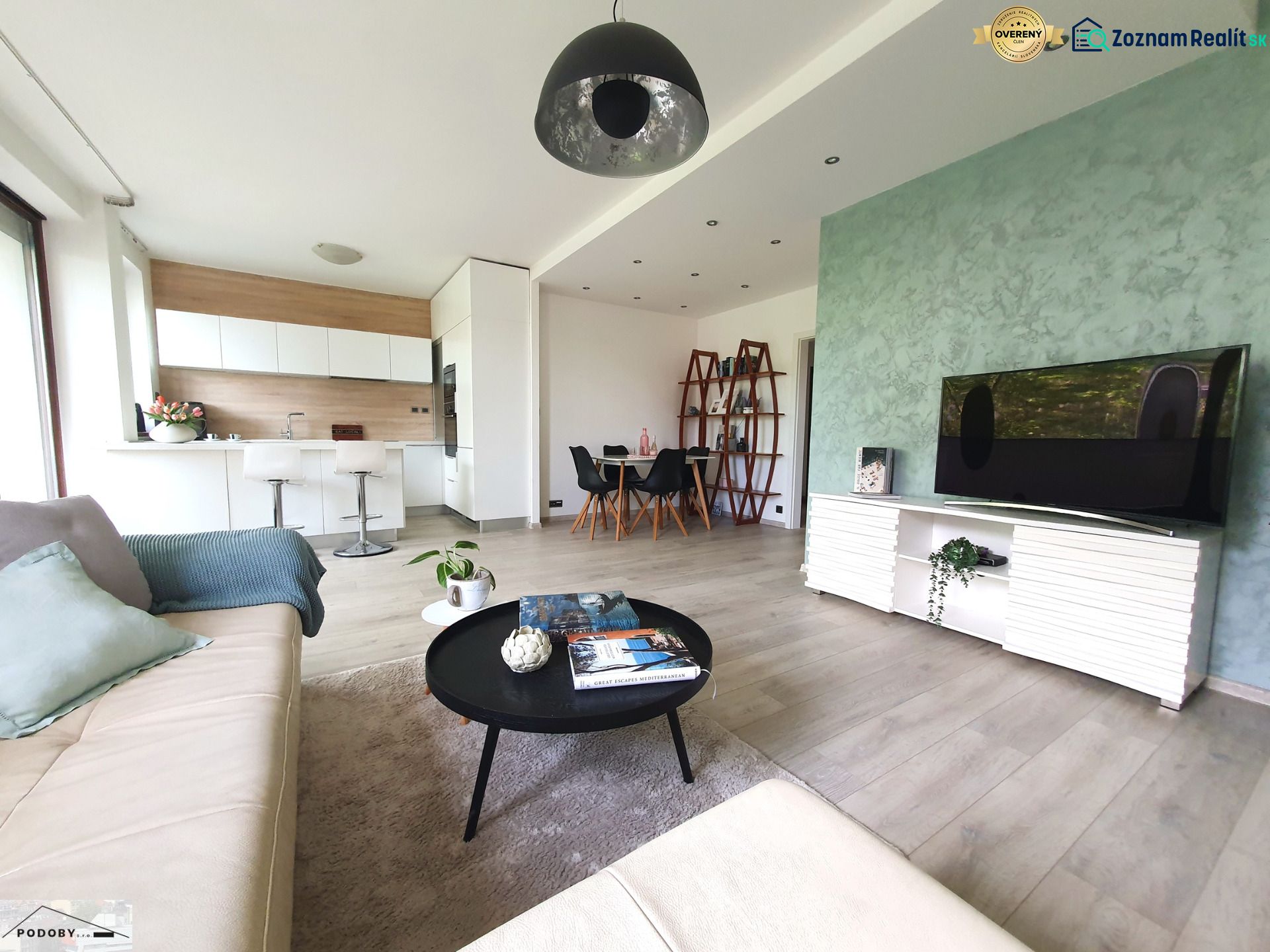 Living room with wood-patterned flooring, open space, and kitchen in a 3-room apartment.