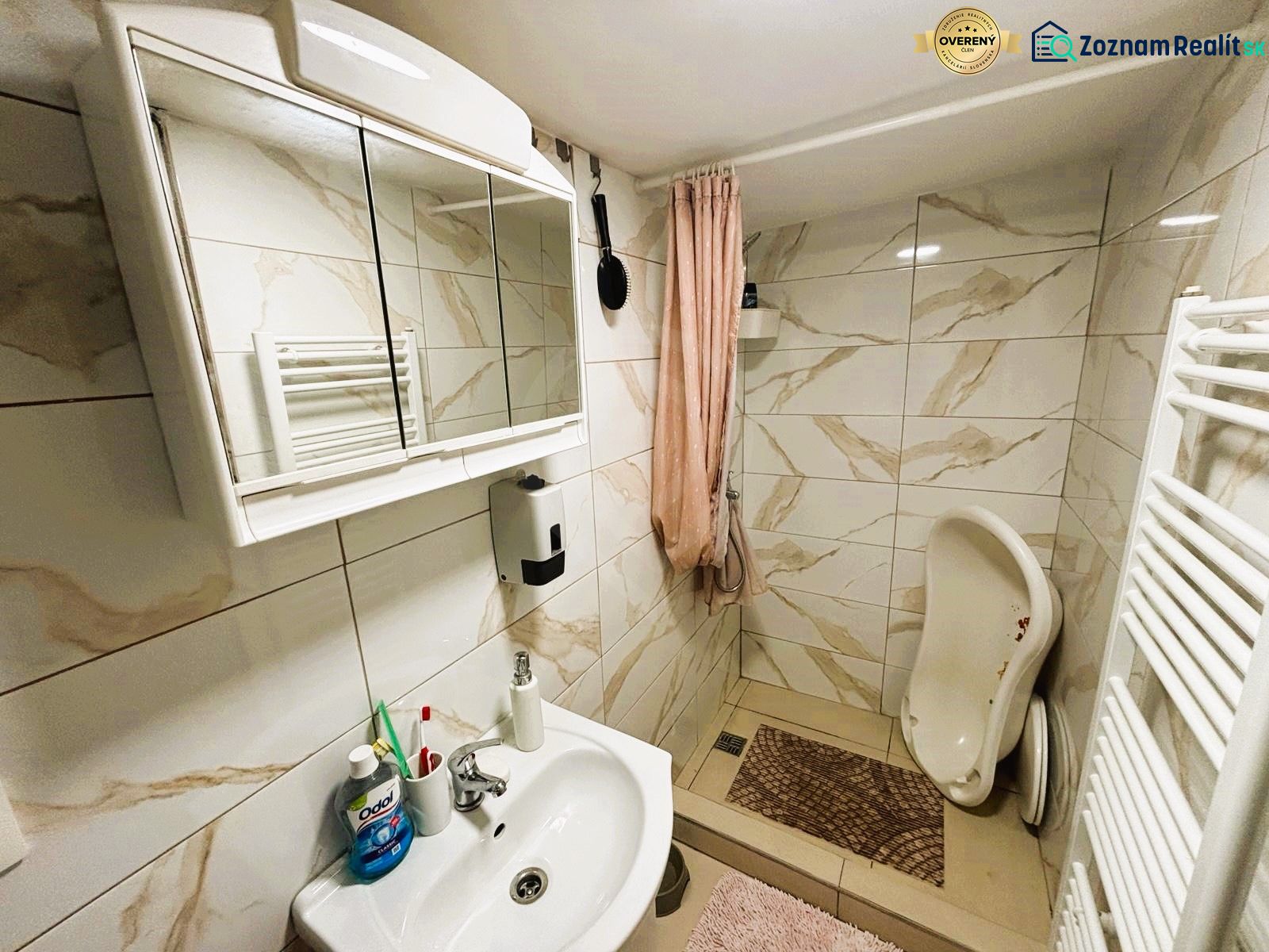 A bathroom in a cabin with a white sink, a mirrored cabinet, and a shower corner.