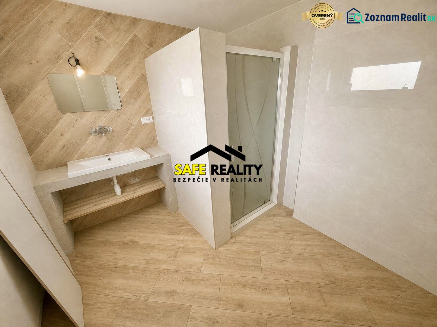 A bathroom in a family house with a wooden decor floor and a shower corner.