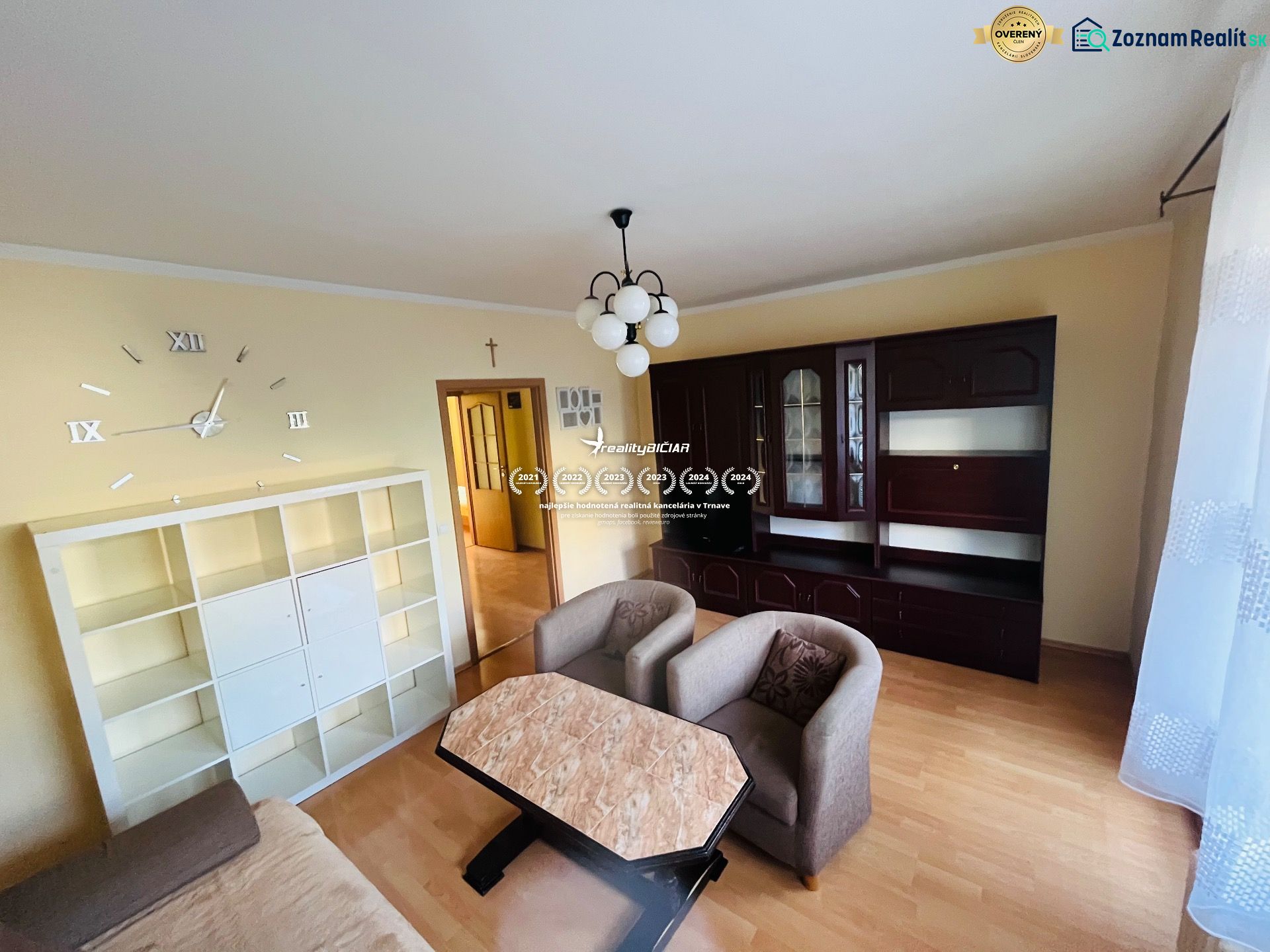 Living room in a 3-room apartment with wooden decor, white and dark cabinet.