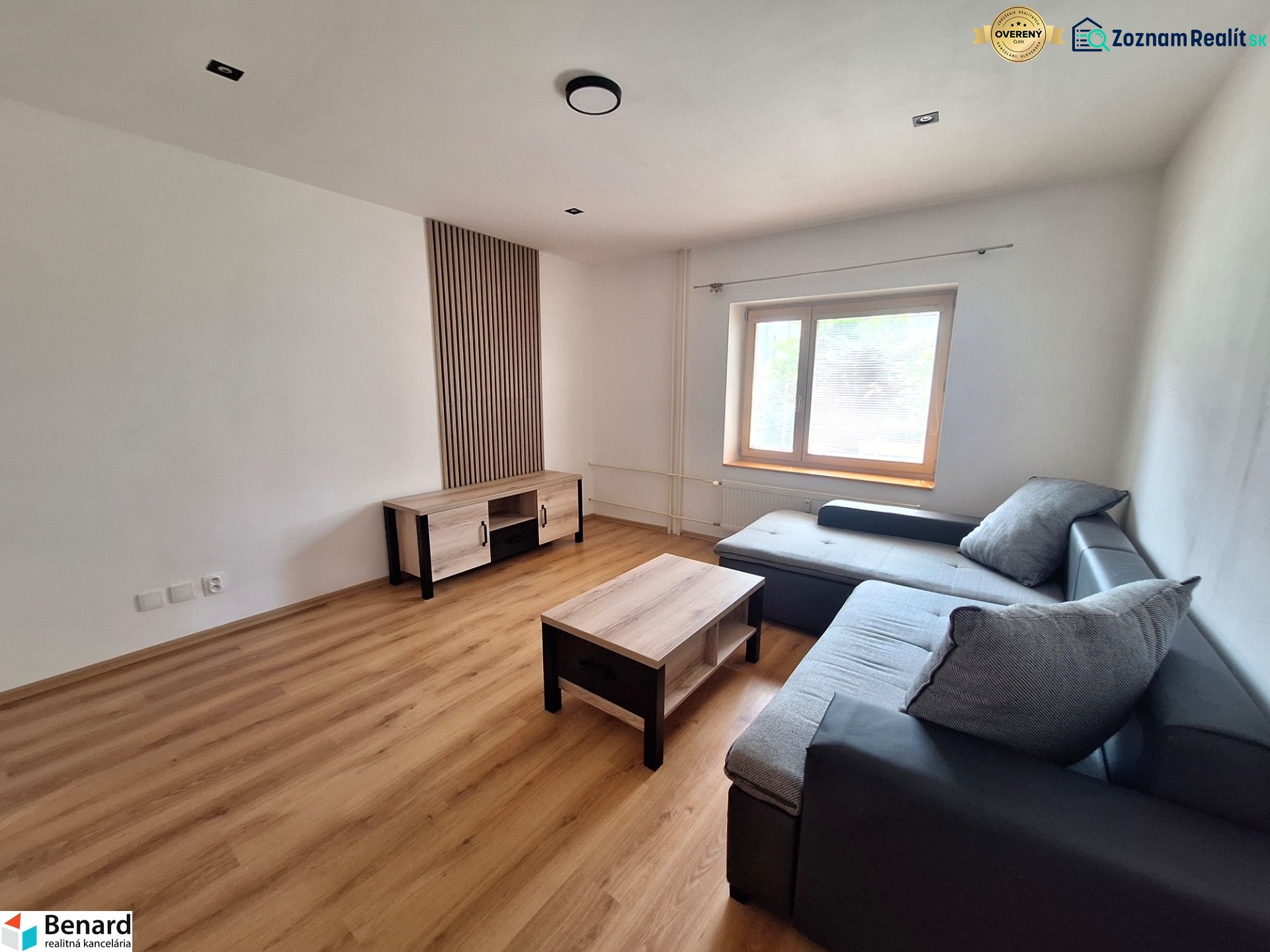 Living room with a corner sofa and wooden furniture in a 2-room apartment.