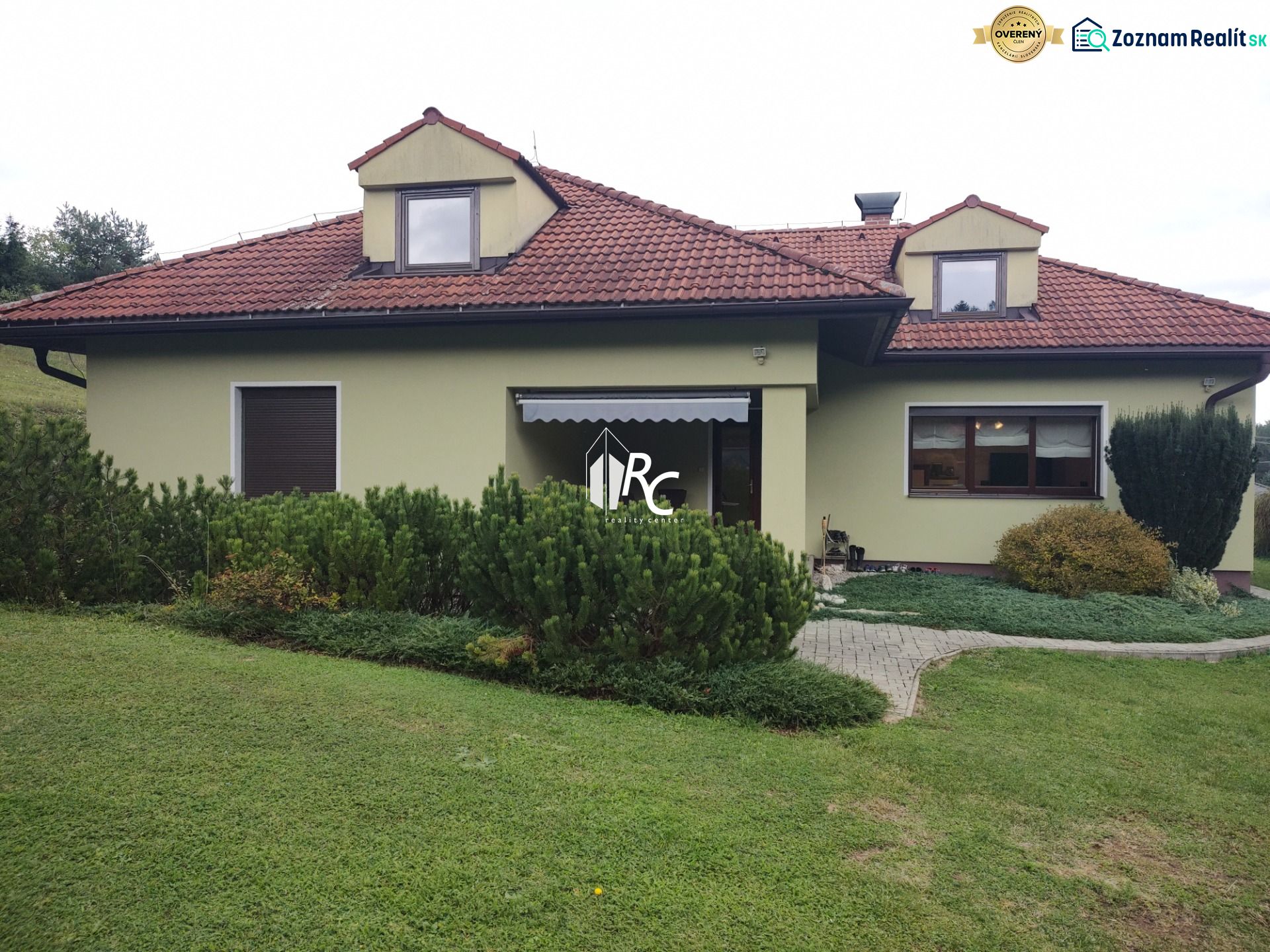 A family house in Trebostovo with a garden, a sloped roof, and a green facade.