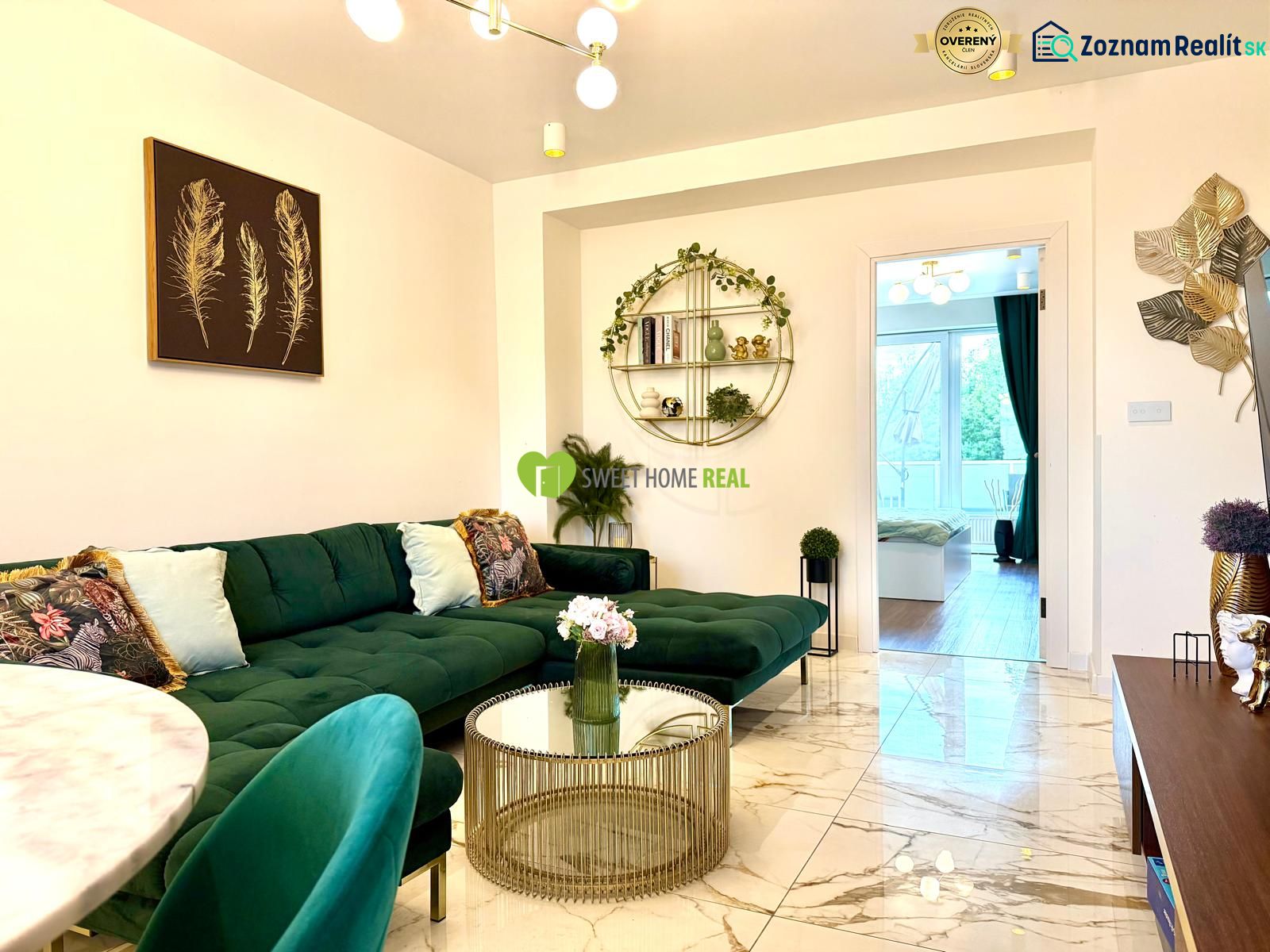 Interior of a 3-room apartment with a sofa, glass table, and artistic decorations on the wall.