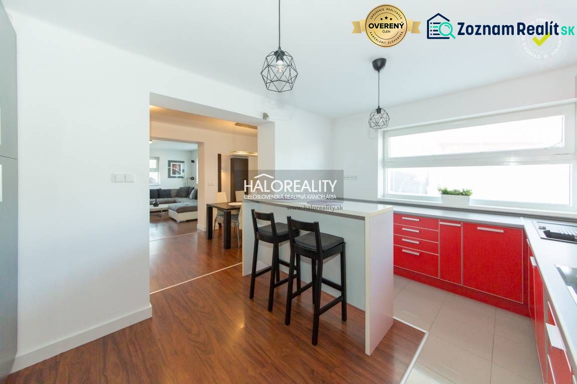 A kitchen in a family house with red kitchen cabinets and a wooden decor floor.