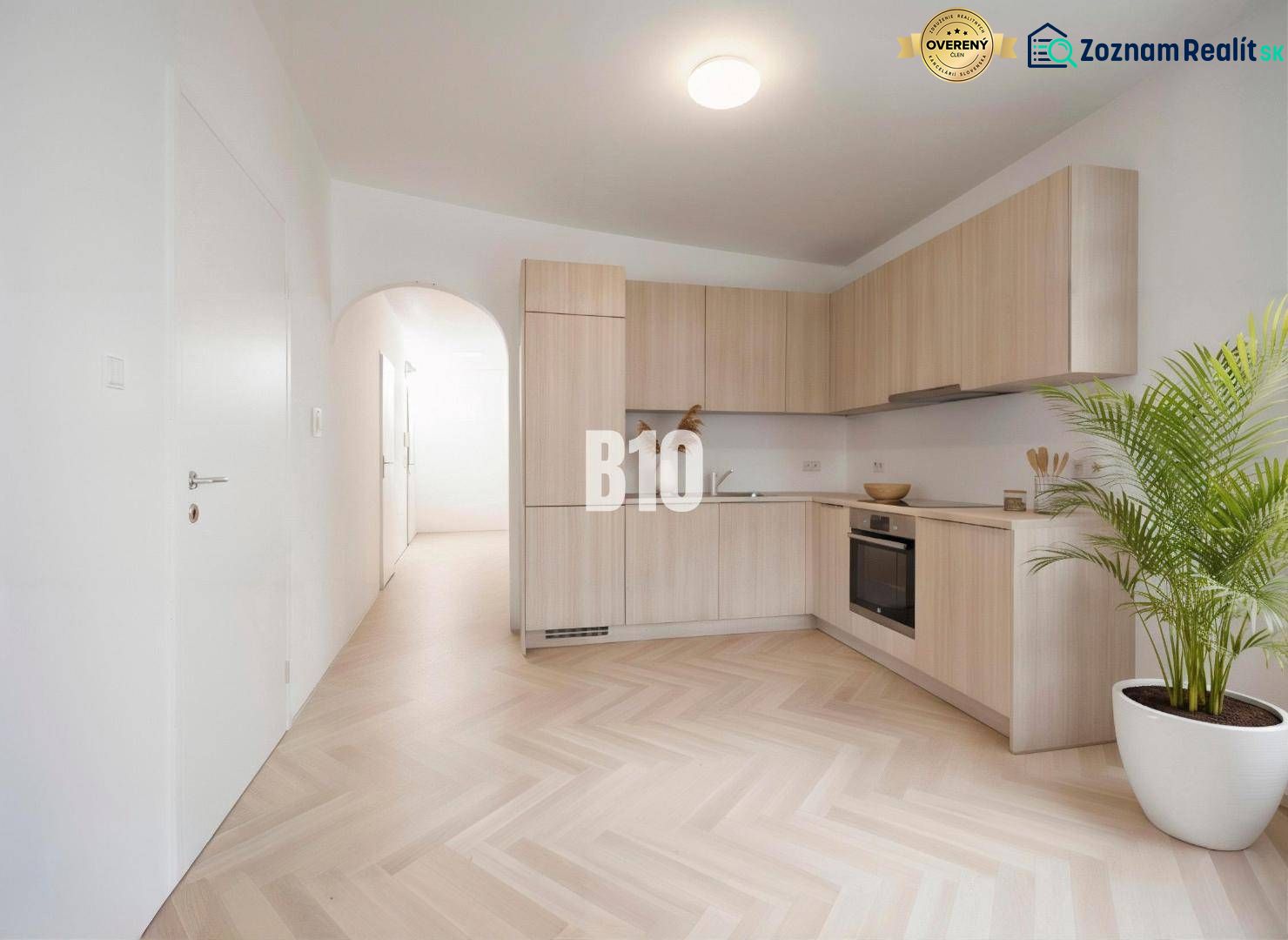 A kitchen in a 4-room apartment with a wooden decor floor and light furniture.