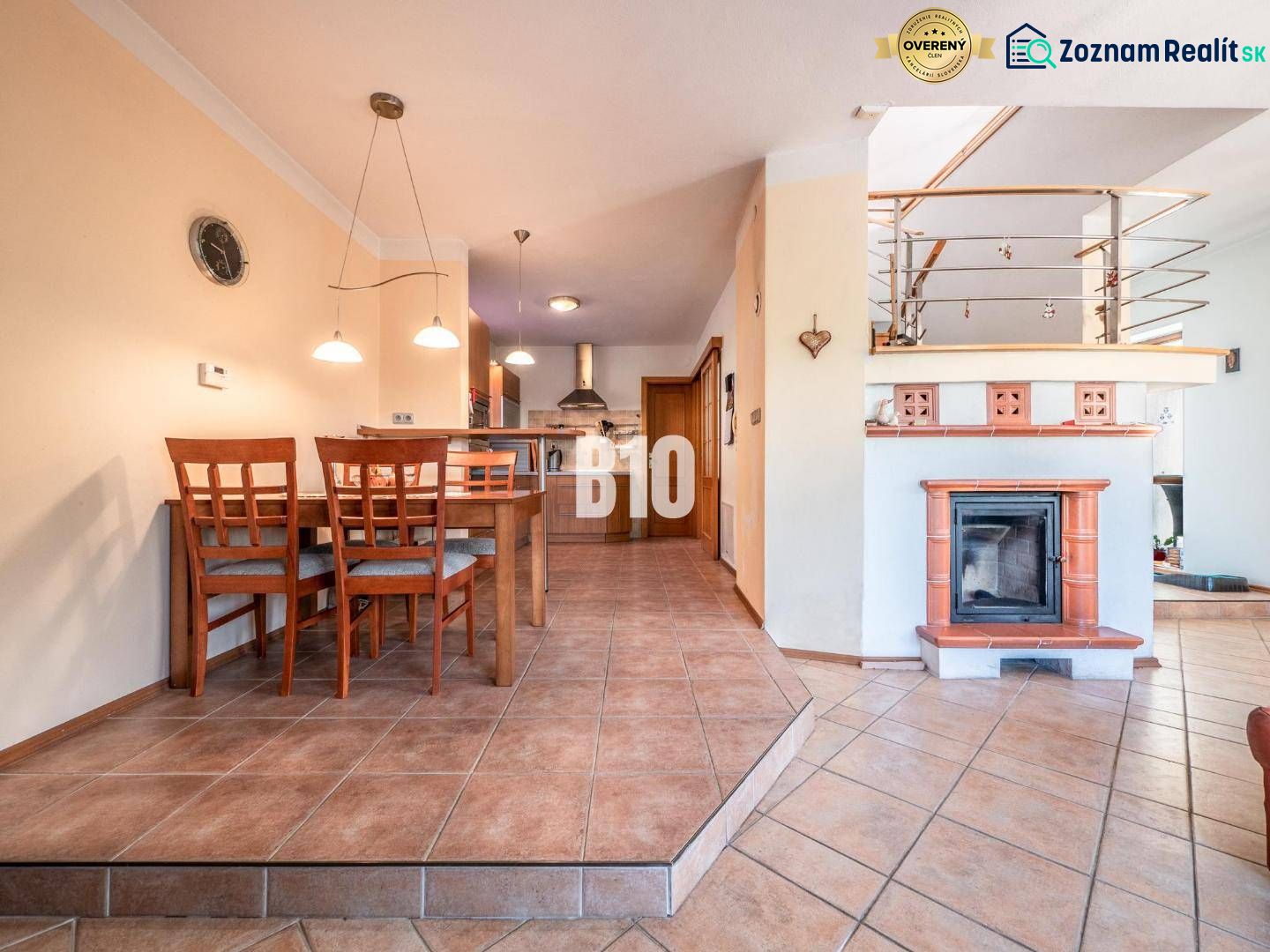 Dining room with a fireplace and kitchen in a family house with ceramic tiles.
