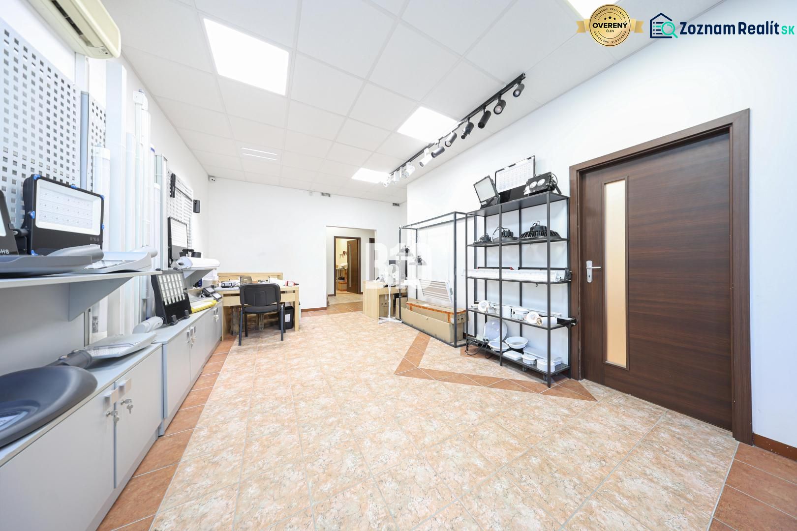Commercial premises with office furniture, shelves, and flooring with a wood decor.