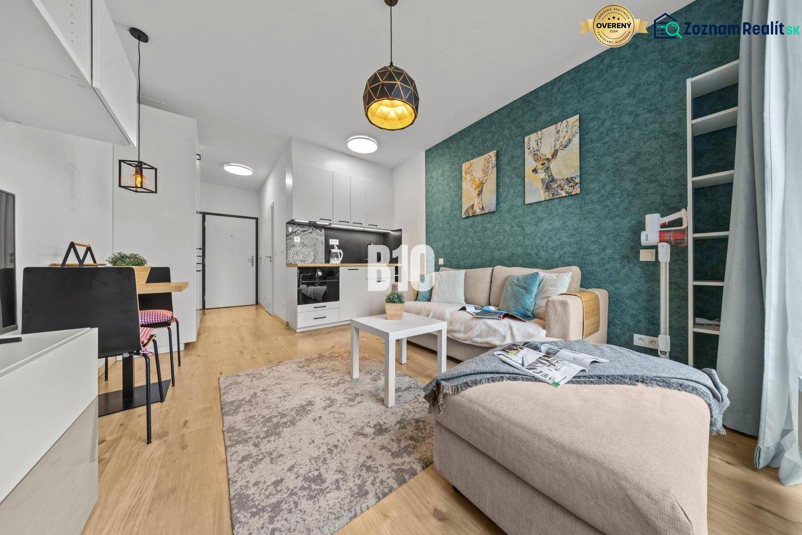 Living room with a kitchenette, sofa, blue wall, and wood-patterned flooring.