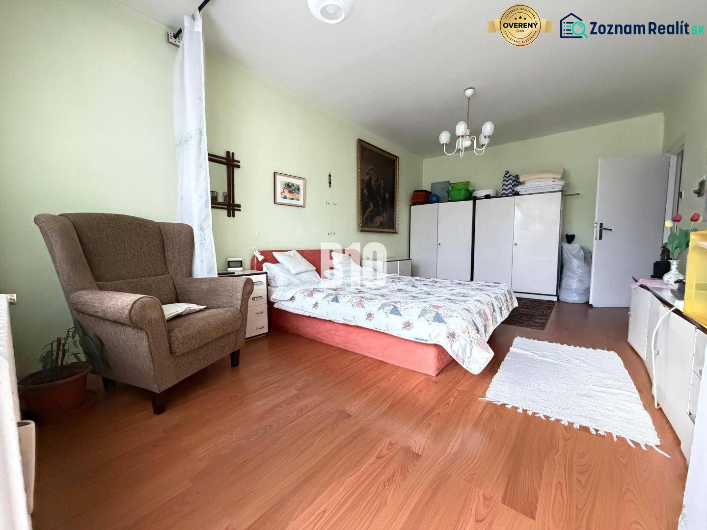A bright room in a 3-room apartment with a wooden decor floor and bedroom furniture.