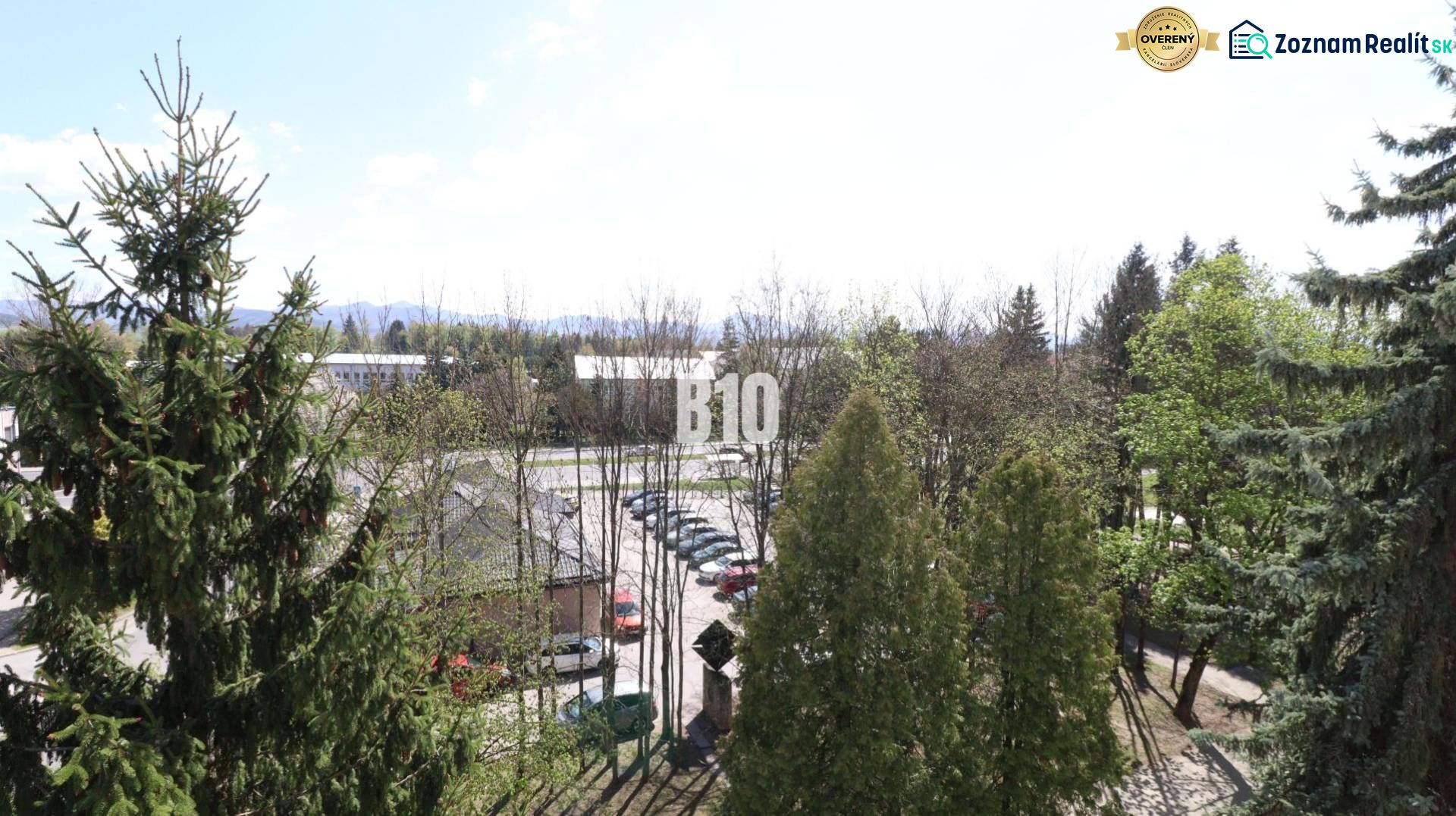 A view from a 3-room apartment in Martin, overlooking greenery and a parking lot.