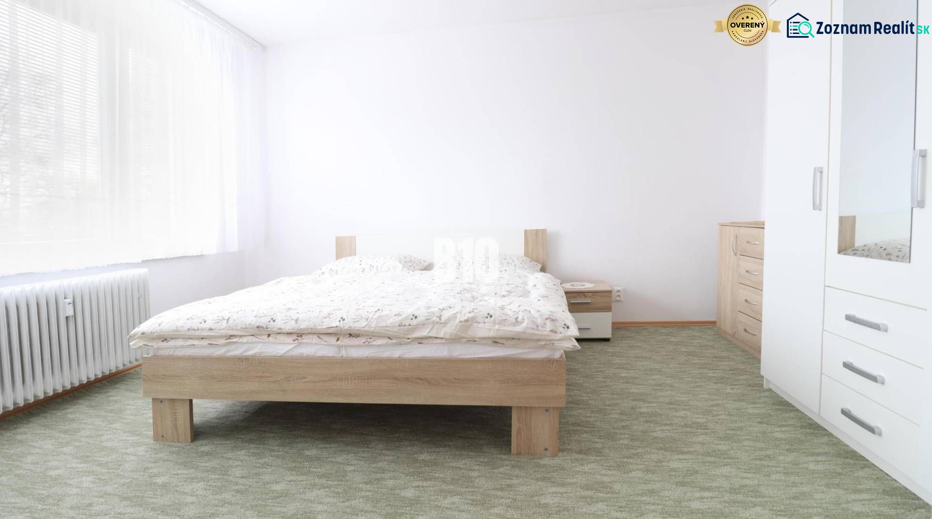 A bedroom in a 3-room apartment with a double bed, white furniture, and a carpet.
