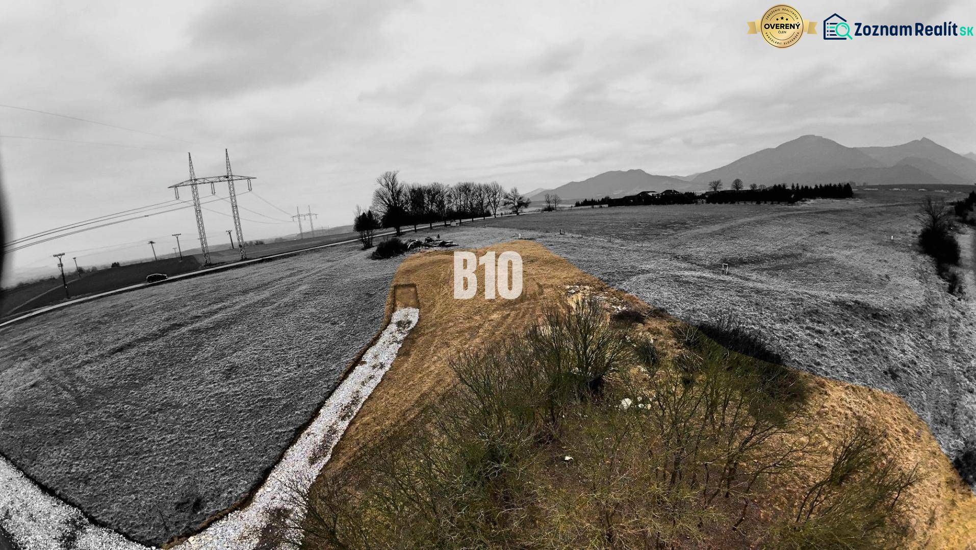 A landscape with a marked residential plot, surrounded by power lines and mountains.