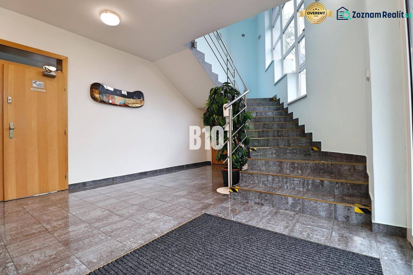 Interior of a production area with a staircase, a plant, and wooden doors.